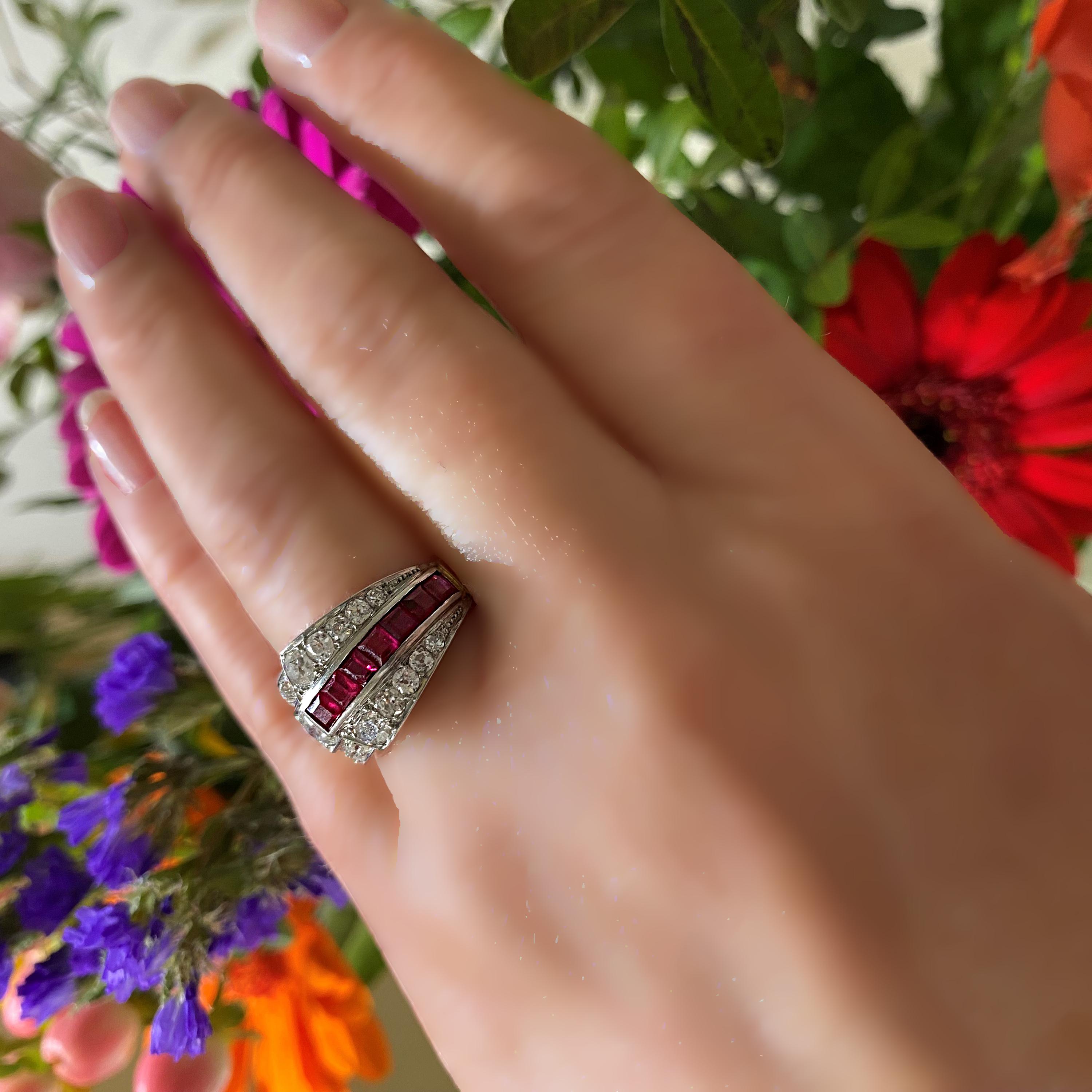 A French Art Deco ruby, diamond and gold ring, by A.F. Souteyrand, Paris, with a row of seven square-cut rubies, in a channel setting, with five, graduating, old-cut diamonds either side, overlapping a larger old-cut diamond, with four, graduating,