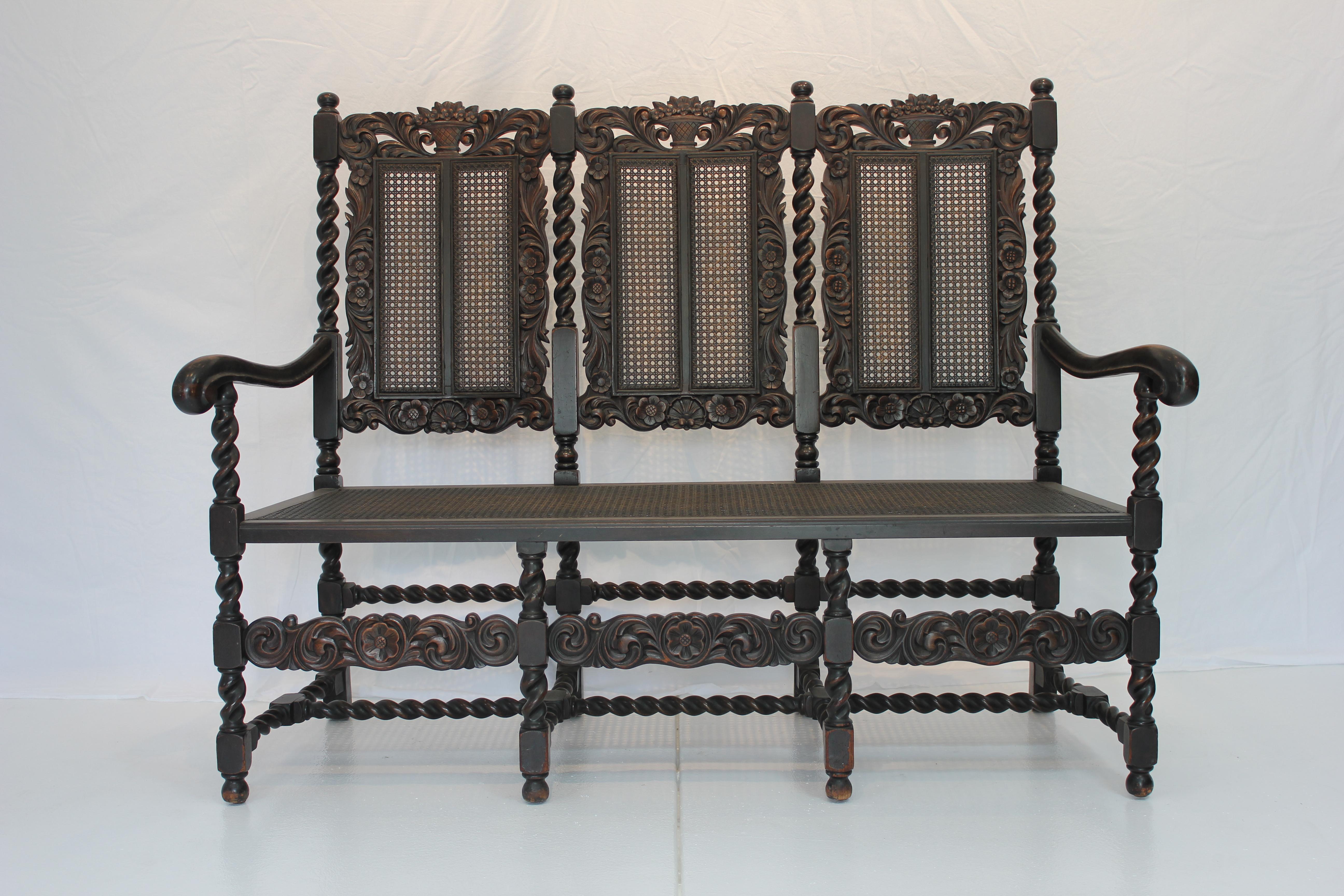 Late 19th Century Heavily Carved Oak English Jacobean Style Settee with Barley Twist legs, stretchers and supports. Caned seat and back.