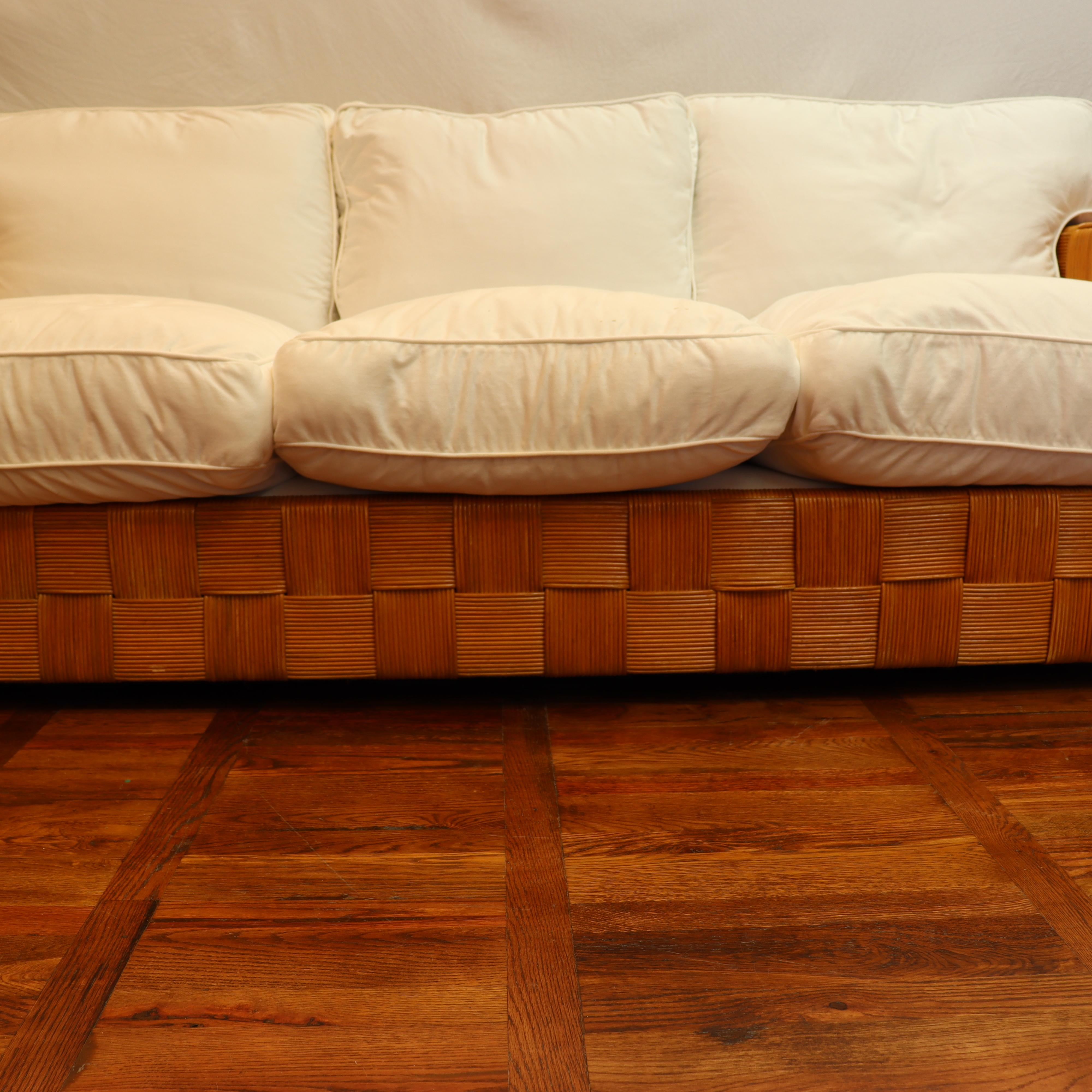 CIRCA 1990 Donghia Block Island Sofa entworfen von John Hutton. Geflochtener Rattanrahmen in sehr gutem Zustand, wie auf den Fotos zu sehen ist. Beide Sitz- und Rückenkissen wurden vor kurzem mit 100% weißem Baumwoll-Denim neu gepolstert. Die