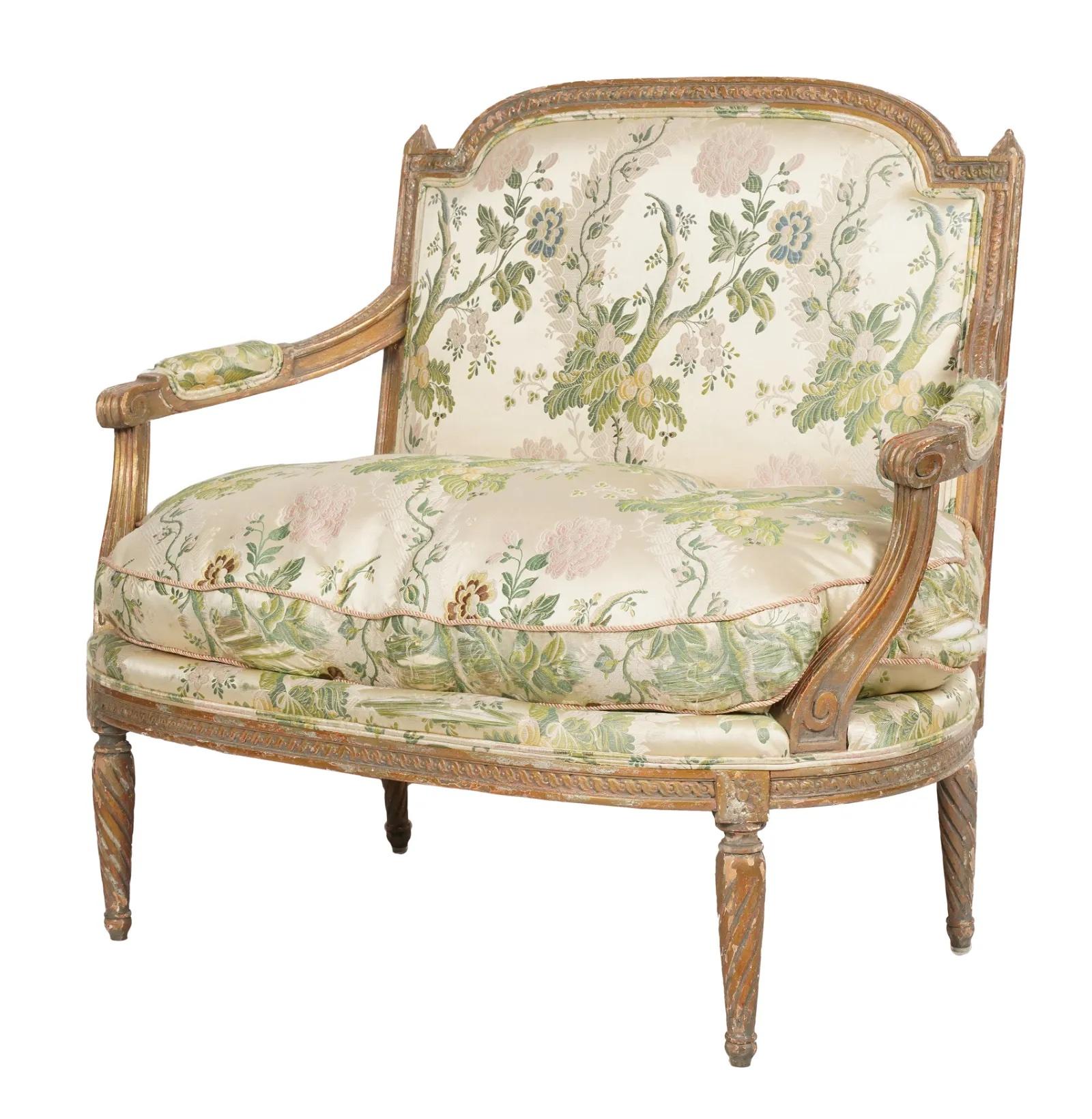 Magnifique canapé en bois doré de style Louis XVI de la fin du XIXe siècle, qui conserve encore des vestiges de la finition en gesso doré d'origine. Le cadre est orné de détails complexes sculptés à la main. La tapisserie d'ameublement en damas de