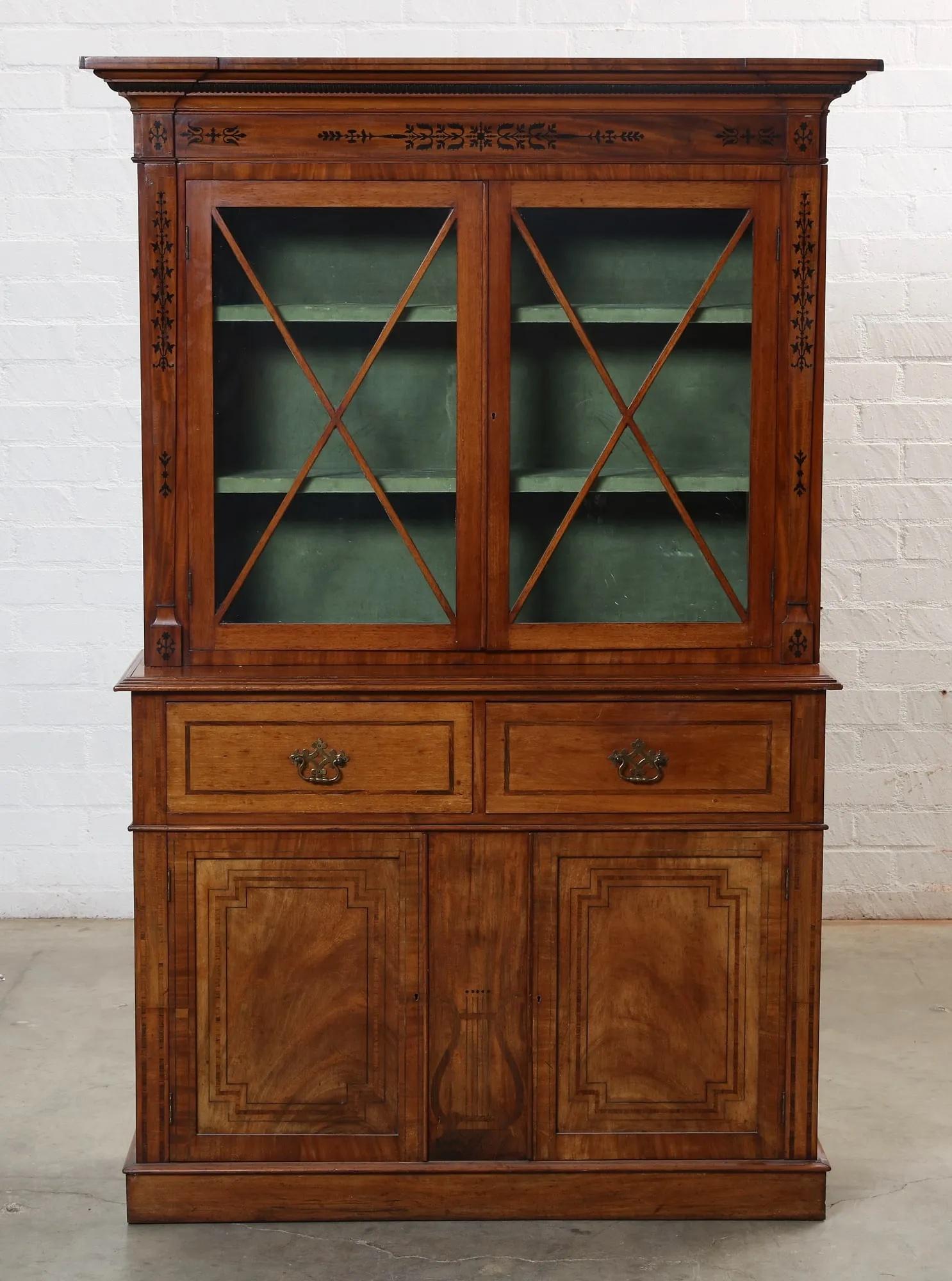 Early 19th Century English Regency Mahogany Inlaid Step Back Cupboard / Bookcase with Intricate Marquetry Detailing. Pair of diagonally cut glazed cabinet doors above pair of dovetailed drawers above two doors opening to lower cabinet compartment.
