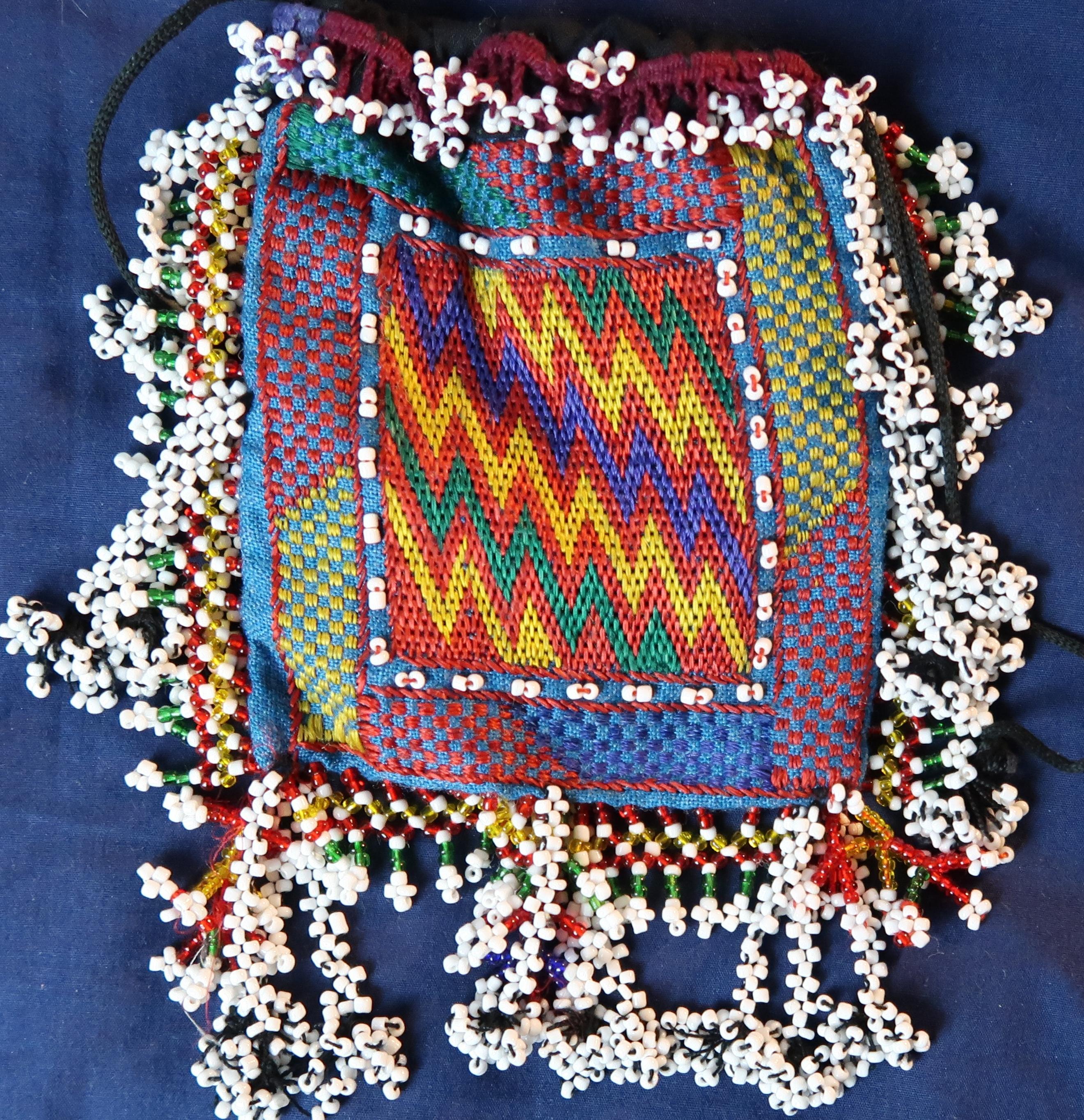 Sweet embroidered coin purse with super beadwork tassels- drawstring to close.

Made by the Hazara tribe from Afghanistan circa 1970- good condition.

Measures: 12 x 14cms
