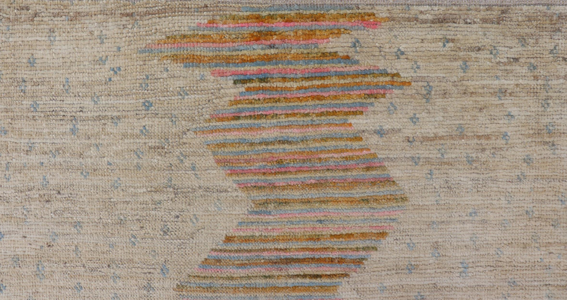 This contemporary piece displays a sandy background with little blue flecks. The design is a modern zig zag design through the face, opening up to a sandy taupe background and finely knotted stripes in jade, blue and pink. 

Keivan Woven Arts; rug