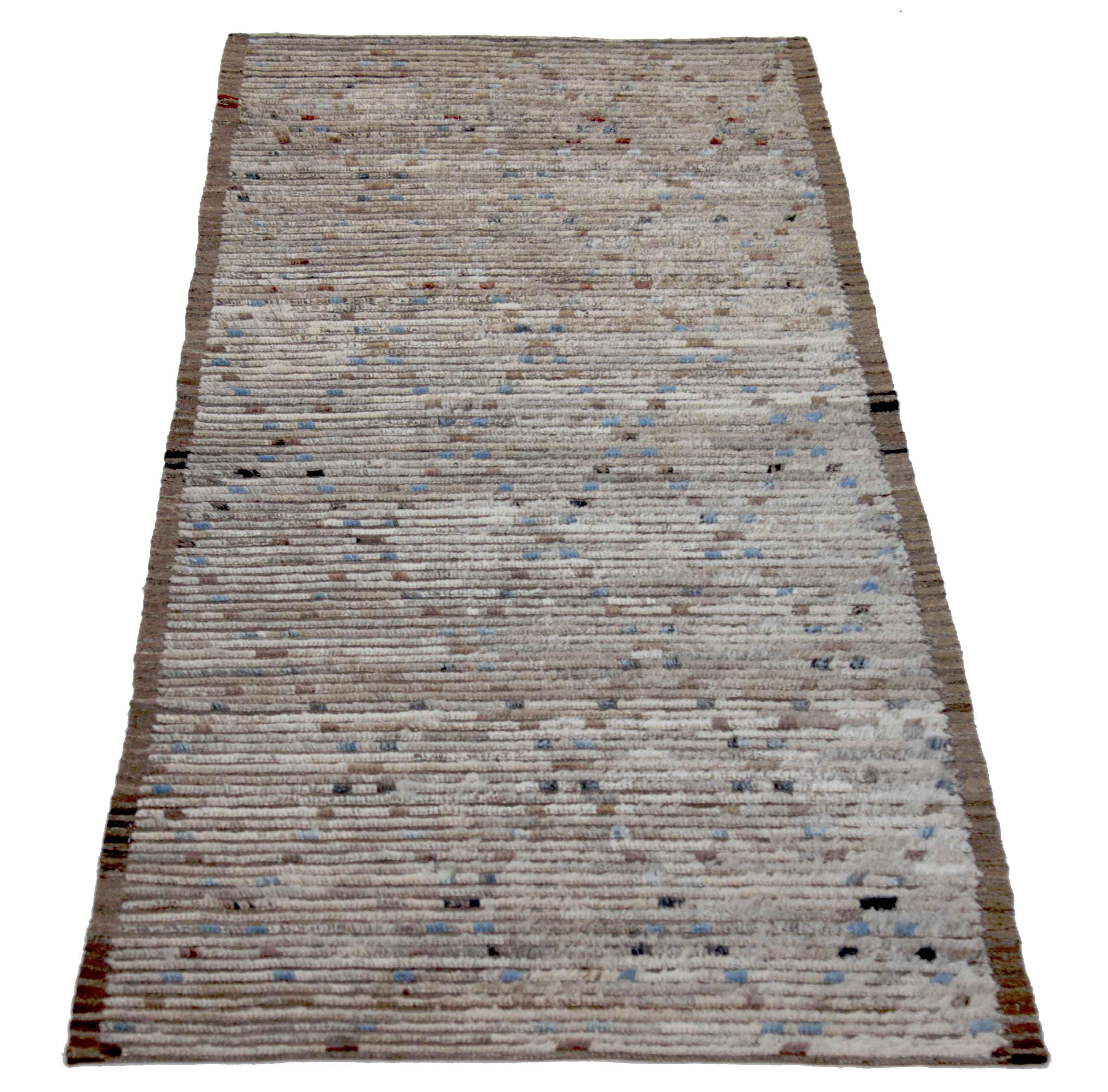 Modern Afghan runner rug handwoven from the finest sheep’s wool. It’s colored with all-natural vegetable dyes that are safe for humans and pets. This piece is a traditional Afghan weaving featuring a Moroccan inspired design. It’s highlighted by