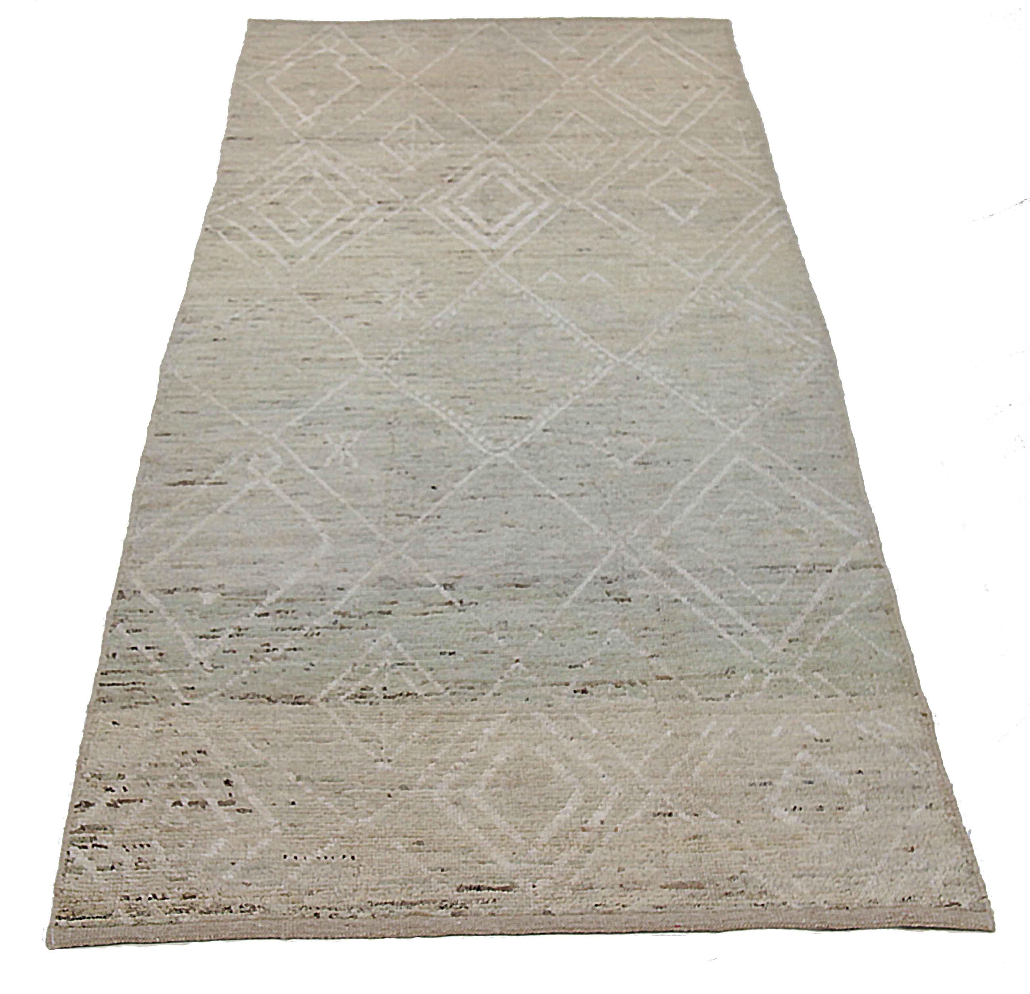 Modern Afghan rug handwoven from the finest sheep’s wool. It’s colored with all-natural vegetable dyes that are safe for humans and pets. This piece is a traditional Afghan weaving featuring a Moroccan inspired design. It’s highlighted by white