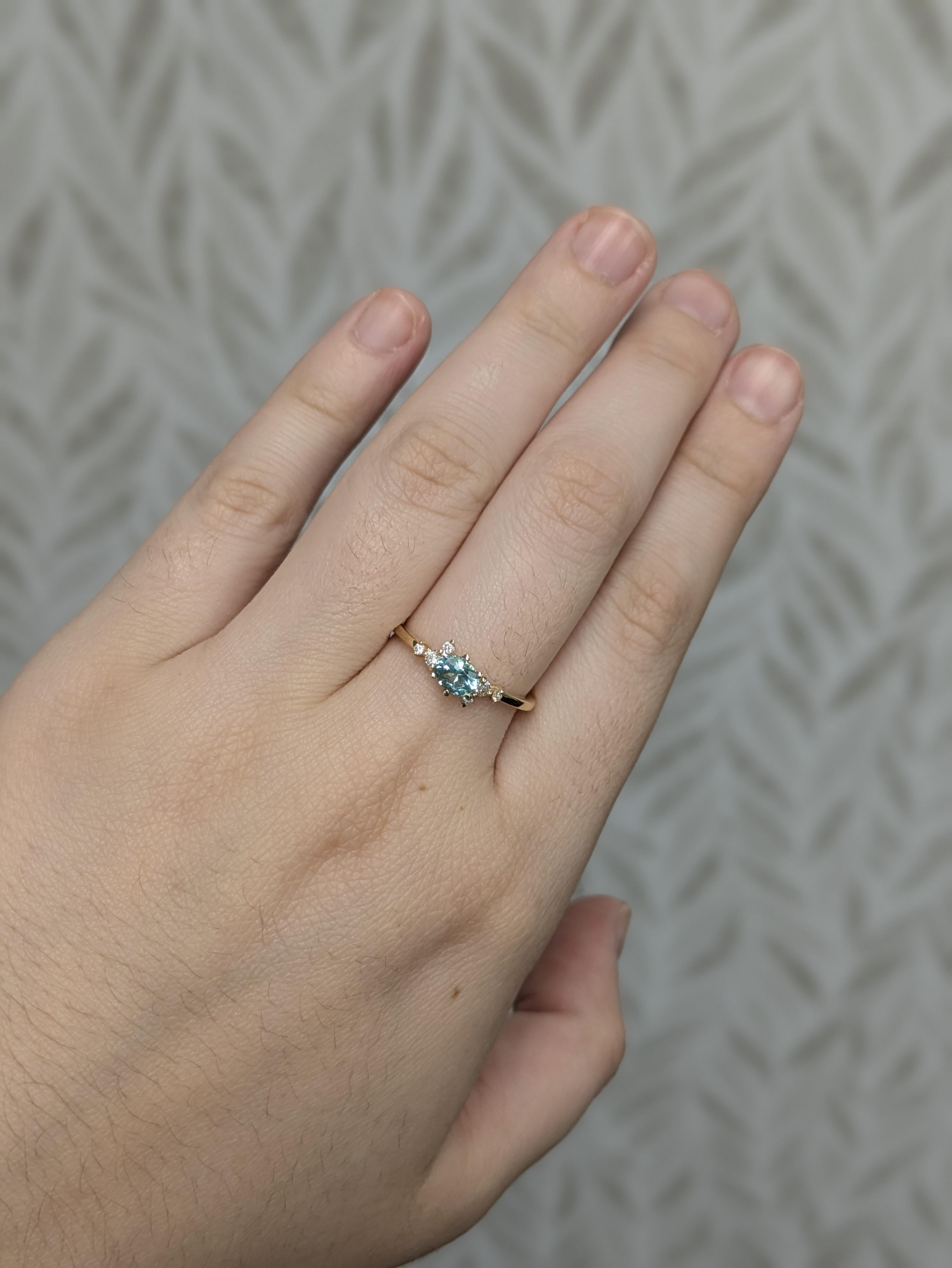 Dieser elegante Ring enthält einen afghanischen Turmalin von 0,52 Karat in einem seltenen blauen Meerschaumton, der an Paraiba-Töne erinnert. Der lebhafte Mittelstein aus 14-karätigem Gold (1,56 g) wird von 6 funkelnden Diamanten von insgesamt 0,10