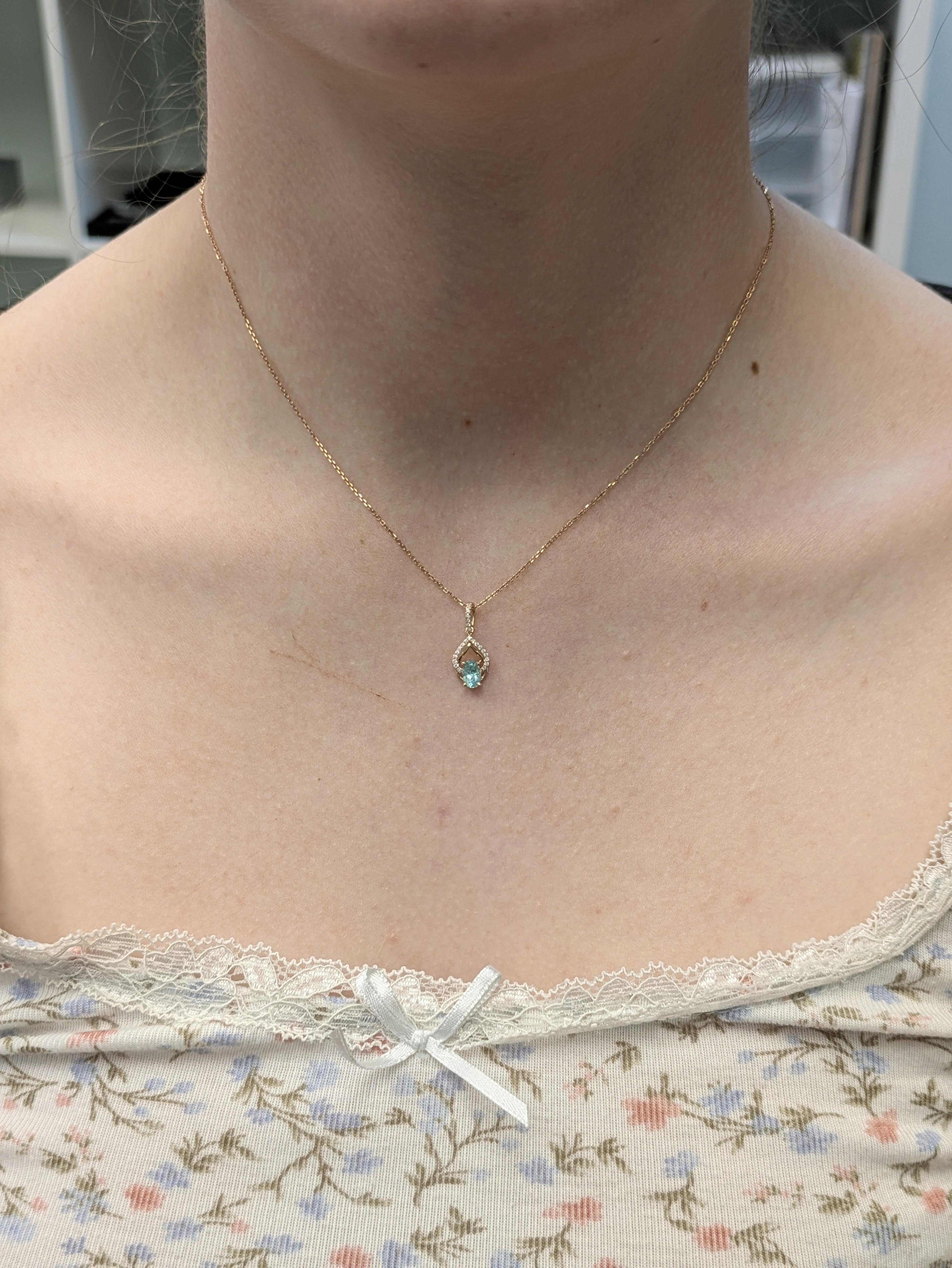 Questo elegante ciondolo presenta una tormalina afgana ovale da 0,44 carati, apprezzata per il suo colore vibrante e la sua chiarezza. Incastonato in una delicata montatura in oro 14k dal peso di 0,82 grammi, è impreziosito da 23 diamanti