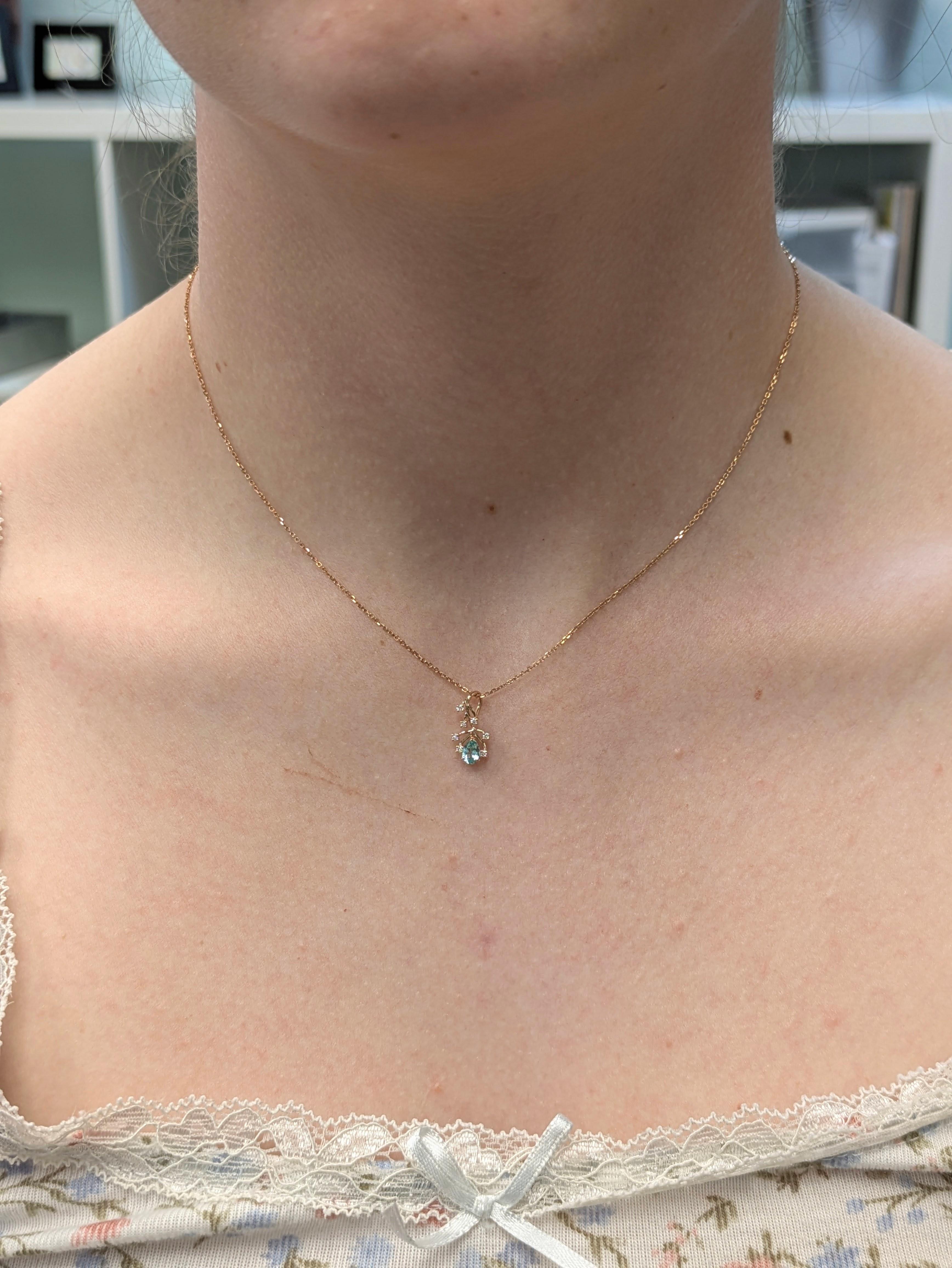 In der Mitte dieses zarten Anhängers befindet sich ein afghanischer Turmalin von 0,22 Karat (5x3 mm), der eine wunderschöne natürliche Farbe aufweist. In einer raffinierten Fassung aus 14 Karat Gold (0,42 g) ist das Schmuckstück mit sieben kleinen