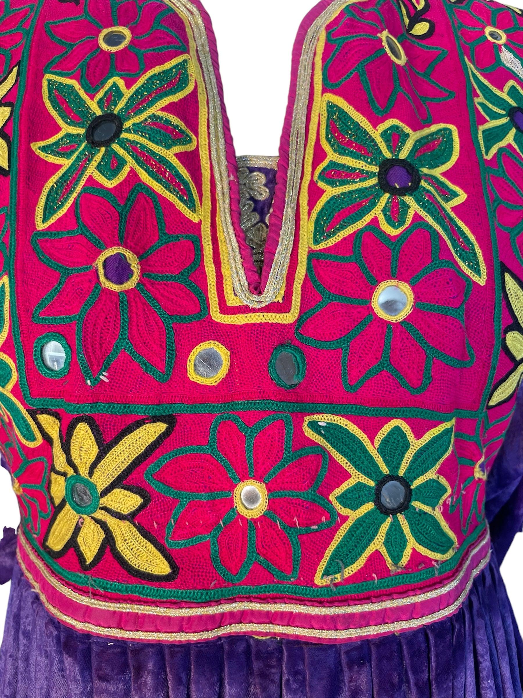 This is a wonderful example of the traditional Kuchi dress found predominately in Afghanistan. This dress is typically ornamented with vests and headdress jewelry and is used in ceremonies. This particular gown is gorgeously hand embroidered, has a