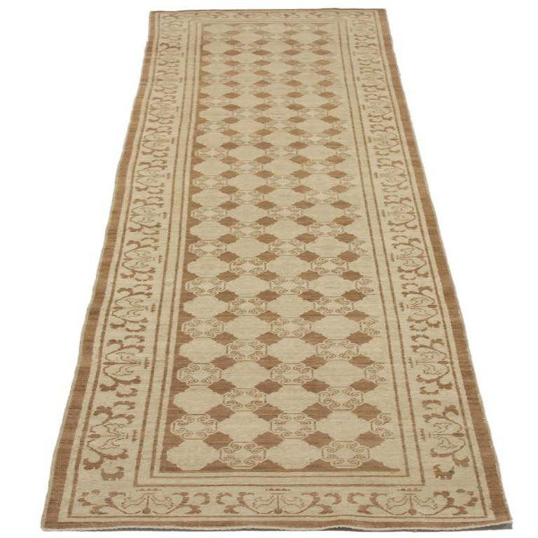 Scopri l'eleganza dell'Afghanistan Khotan con il tappeto runner CIRCA 1990. Progettato in lana e marrone-avorio, questo design esclusivo è perfetto per valorizzare il tuo spazio.