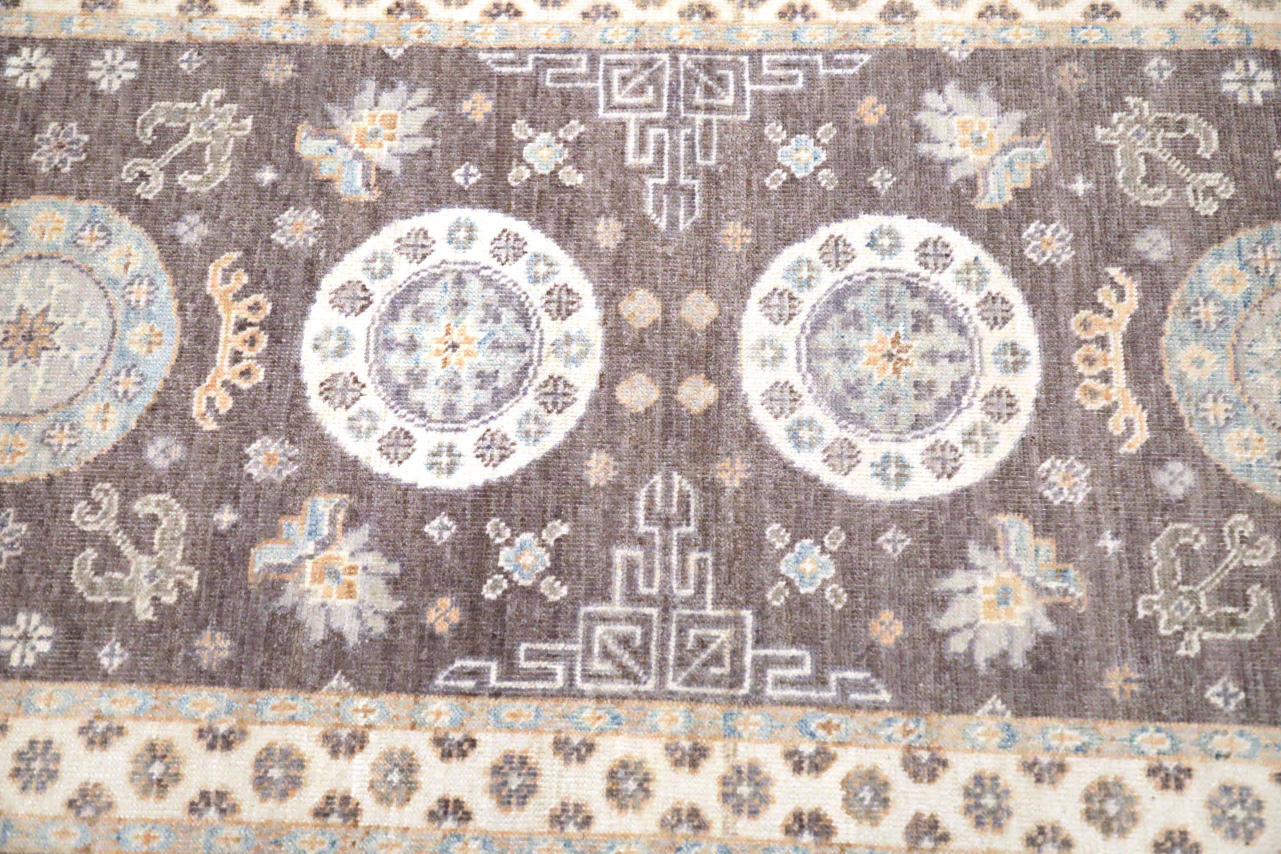 Entdecken Sie die Eleganz des afghanischen Khotan-Teppichs mit Läufer aus der Zeit um 1990. Dieses exklusive Design aus Wolle und Braun-Elfenbein ist perfekt, um Ihren Raum zu verschönern.