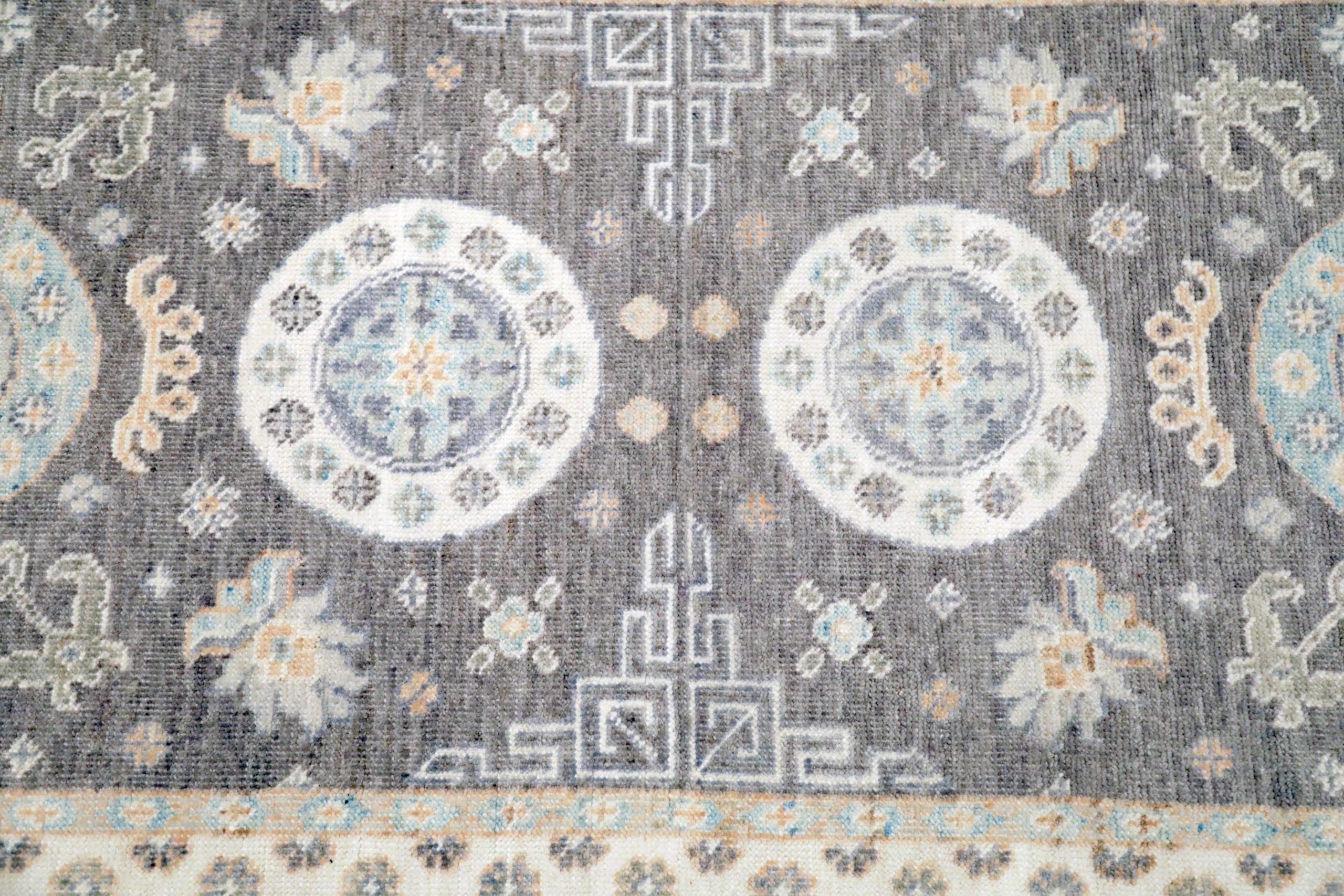 Afghan Khotan Runner: Grey-Purple & Circular Medallions

A Graceful Path of Profound Hues and Intricate Design
This captivating Afghan Khotan runner offers sophisticated artistry. Its elongated field, in a deep grey-purple, provides a tranquil