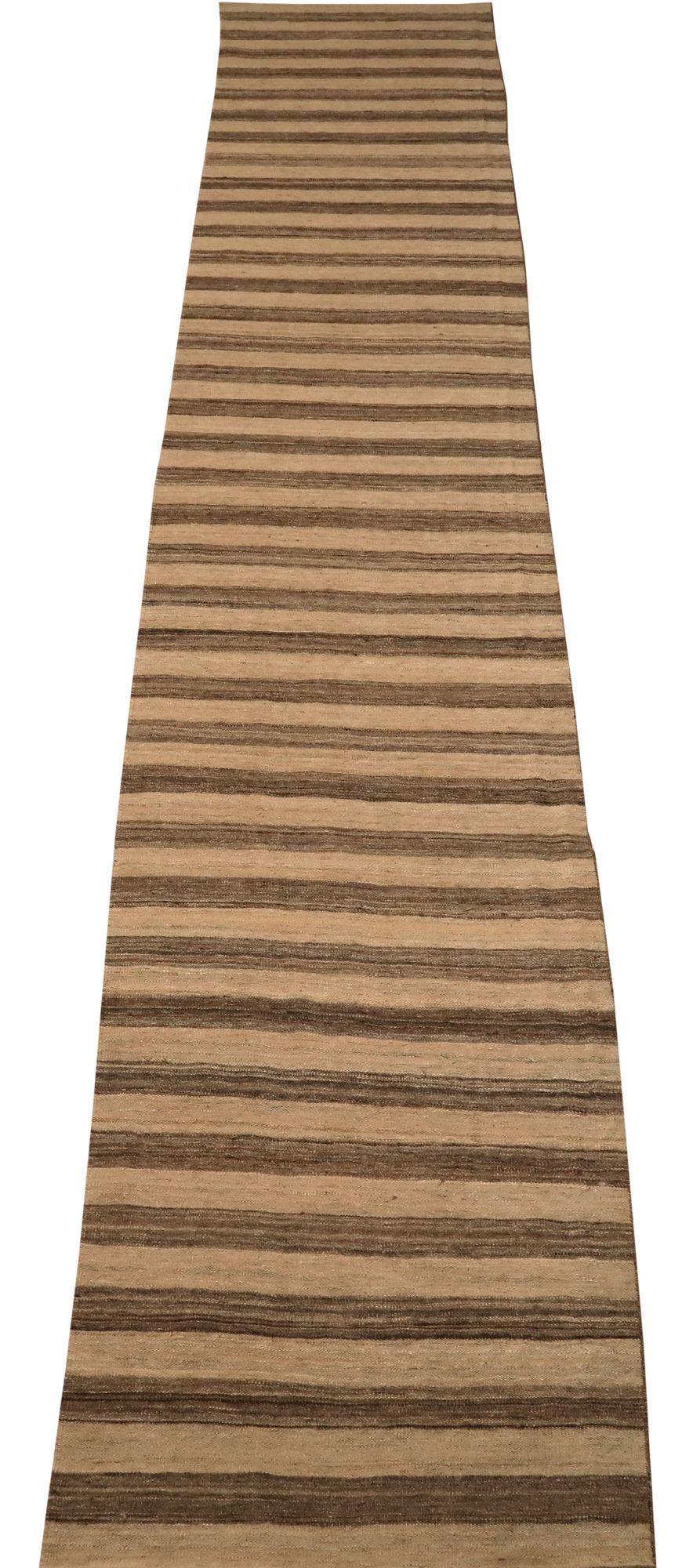 Entdecken Sie die Eleganz eines afghanischen Kilims mit einem Läufer aus der Zeit um 1990. Dieses exklusive Design aus Wolle und Braun-Elfenbein ist perfekt, um Ihren Raum zu verschönern.
