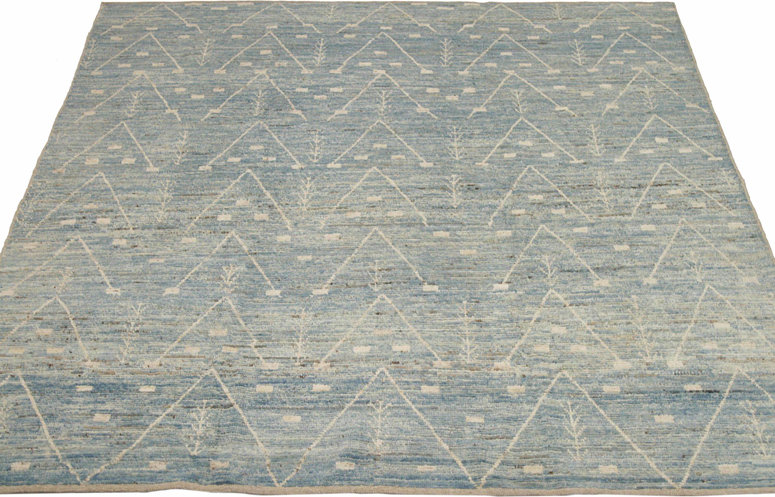Entdecken Sie die Eleganz der marokkanischen Teppiche aus Afghanistan, die um 1990 entstanden sind. Dieses exklusive Design aus Wolle und Blau-Elfenbein eignet sich perfekt, um Ihren Raum zu verschönern.