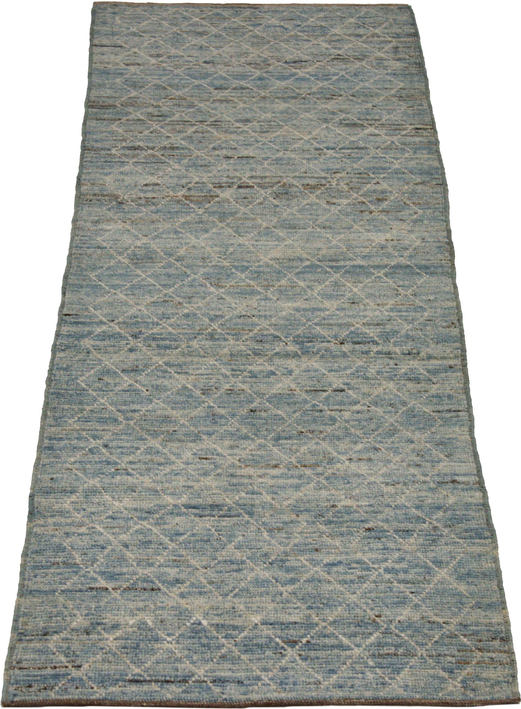 Entdecken Sie die Eleganz des marokkanischen Afghanistans mit dem Läufer von CIRCA 1990. Dieses exklusive Design aus Wolle und Blau-Elfenbein eignet sich perfekt, um Ihren Raum zu verschönern.