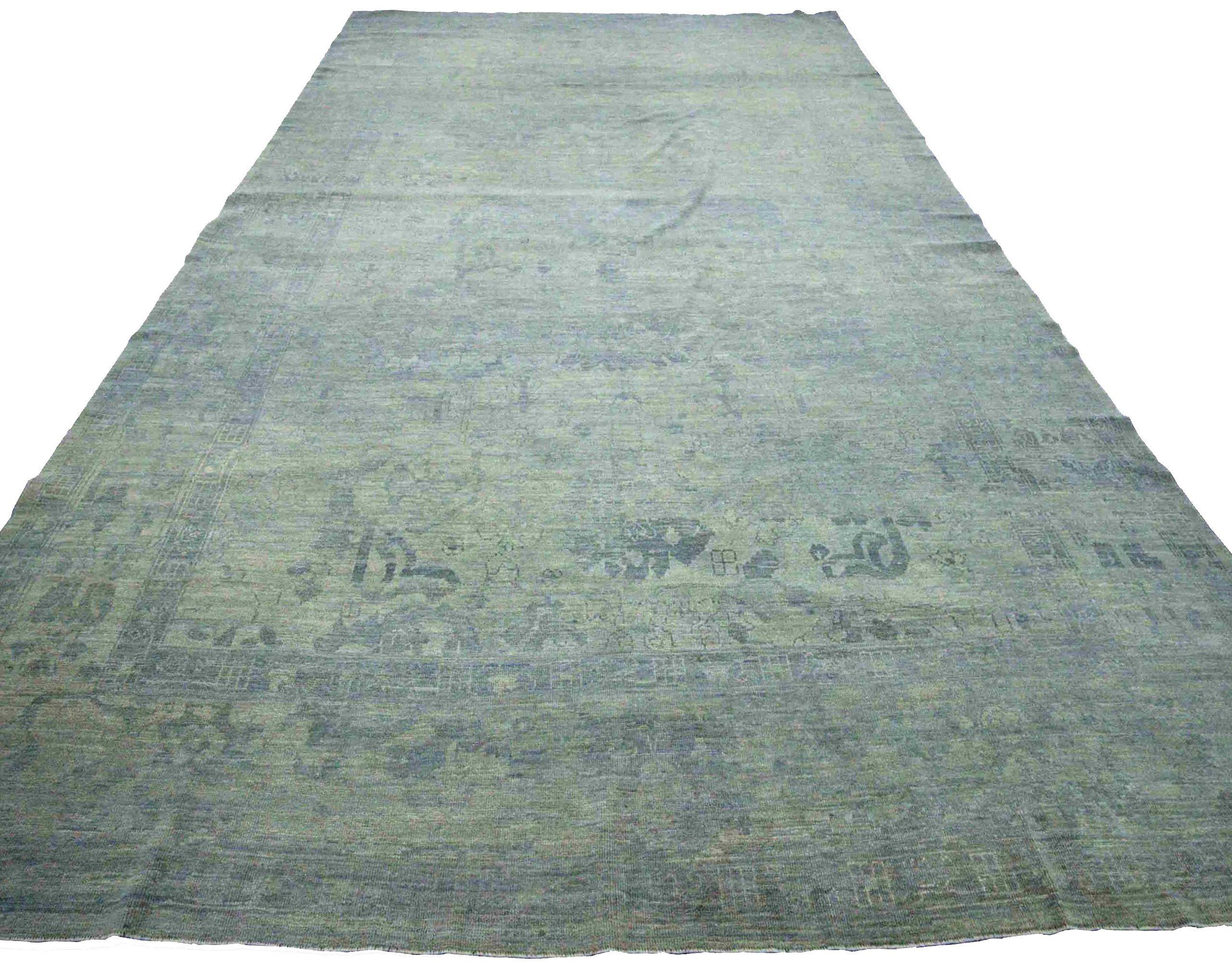 Découvrez l'élégance de l'Afghanistan Oushak qui présente un tapis Over Size de Circa 1990. Conçu avec de la laine et du BlueGrayGreen, ce design exclusif est parfait pour mettre en valeur votre espace.