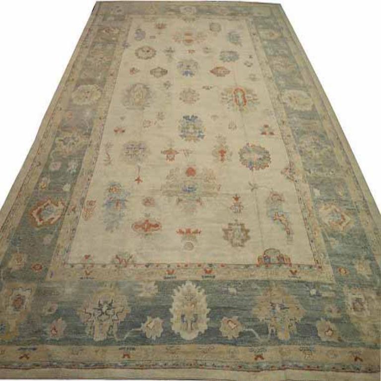 Entdecken Sie die Eleganz von Afghanistan Oushak mit einem übergroßen Teppich von CIRCA 1990. Dieses exklusive Design aus Wolle und Blau-Elfenbein-Rot ist perfekt, um Ihren Raum zu verschönern.