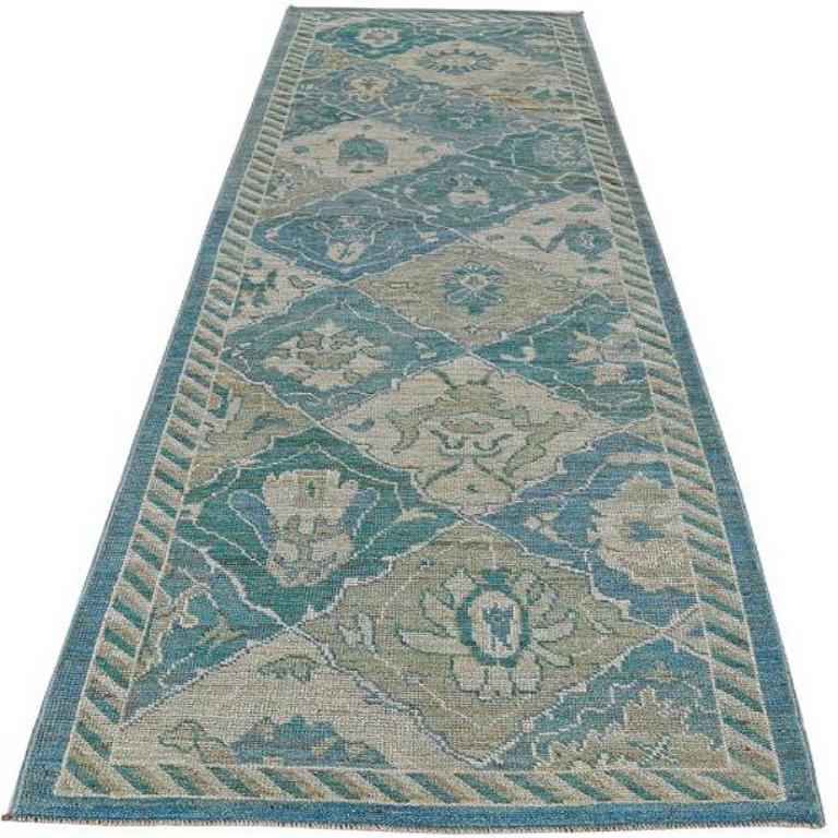 Scopri l'eleganza della collezione Afghanistan Rose con il tappeto Runner di CIRCA 1990. Progettato con lana e blu-verde-avorio, questo design esclusivo è perfetto per valorizzare il tuo spazio.
