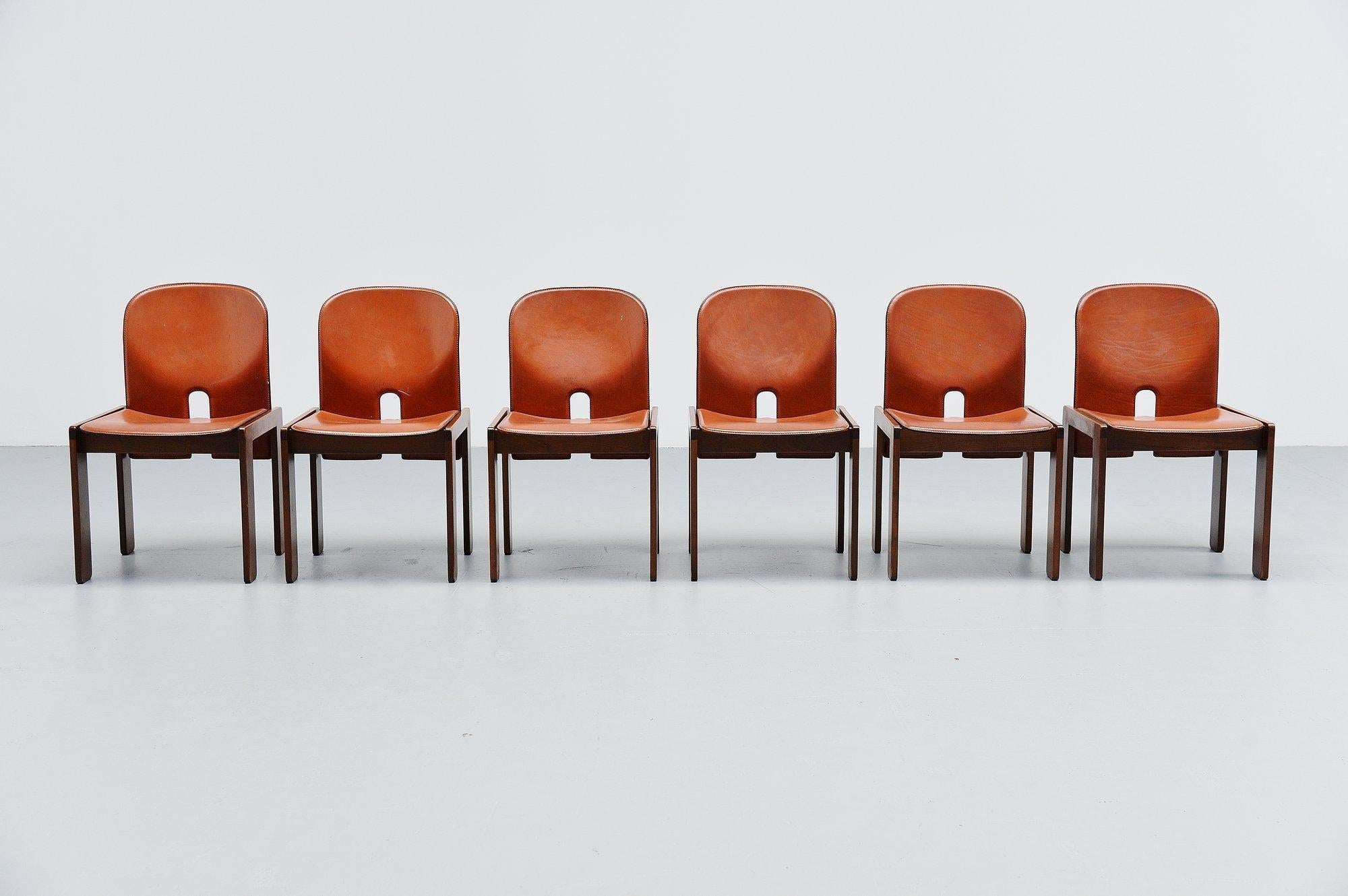 Nice set of 6 model 121 dining chairs designed by Afra e Tobia Scarpa and manufactured by Cassina, Italy 1965. These chairs have walnut wooden frames and plywood seats and backs covered with cognac colored leather. Chairs are marked with the Cassina