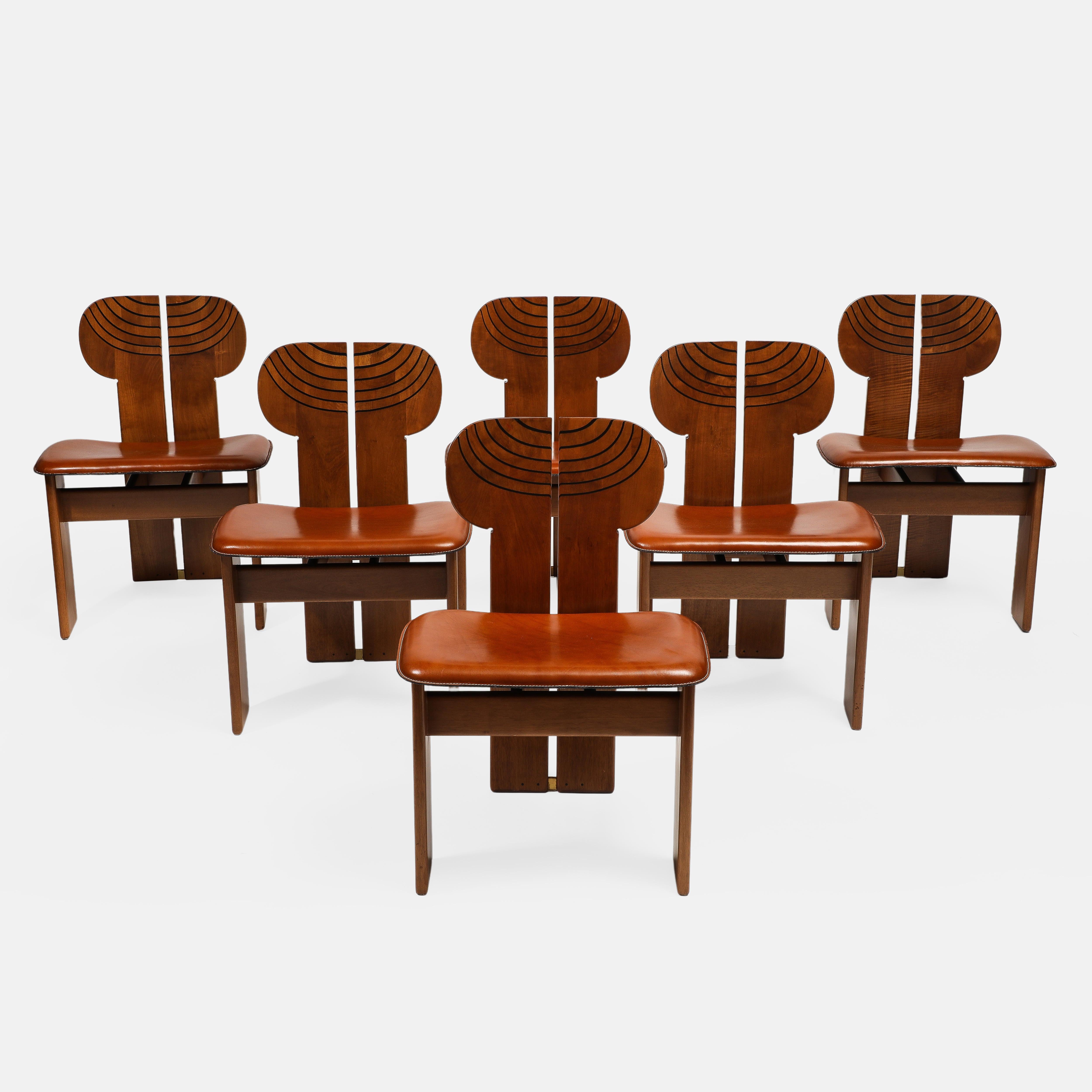 Disegnato da Afra & Tobia Scarpa per Maxalto straordinario set di dodici sedie da pranzo modello 'Africa' con struttura scultorea in noce ed ebano e sedili in cuoio o pelle cognac, Italia, 1975.  

Queste sedie da pranzo scultoree e moderniste hanno