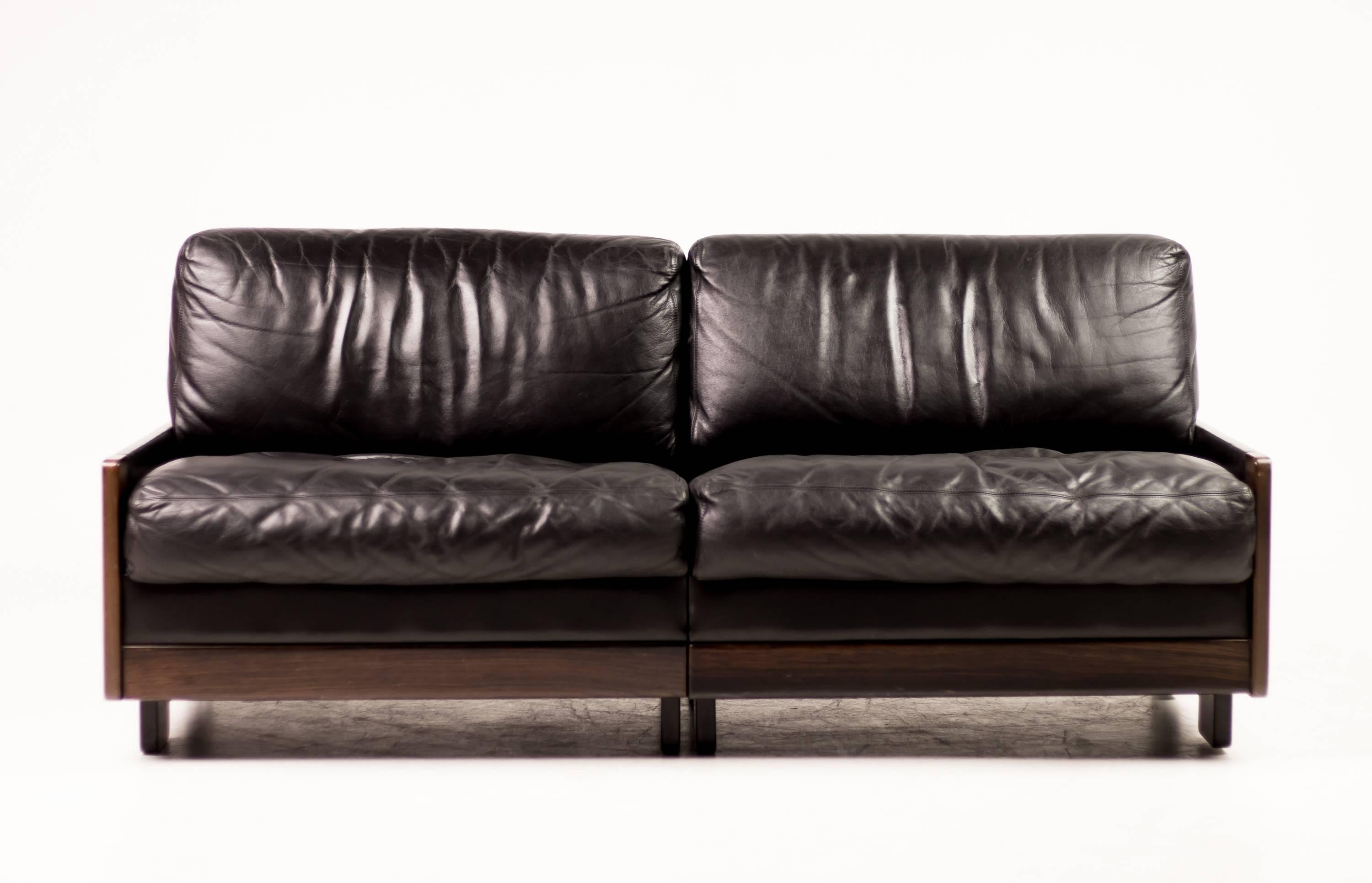 Sofa manufactured by Cassina in 1966, designed by Afra and Tobia Scarpa.
Mahogany frame with black leather covering the sides and back, seat and back cushions. 
Base in black painted wood.