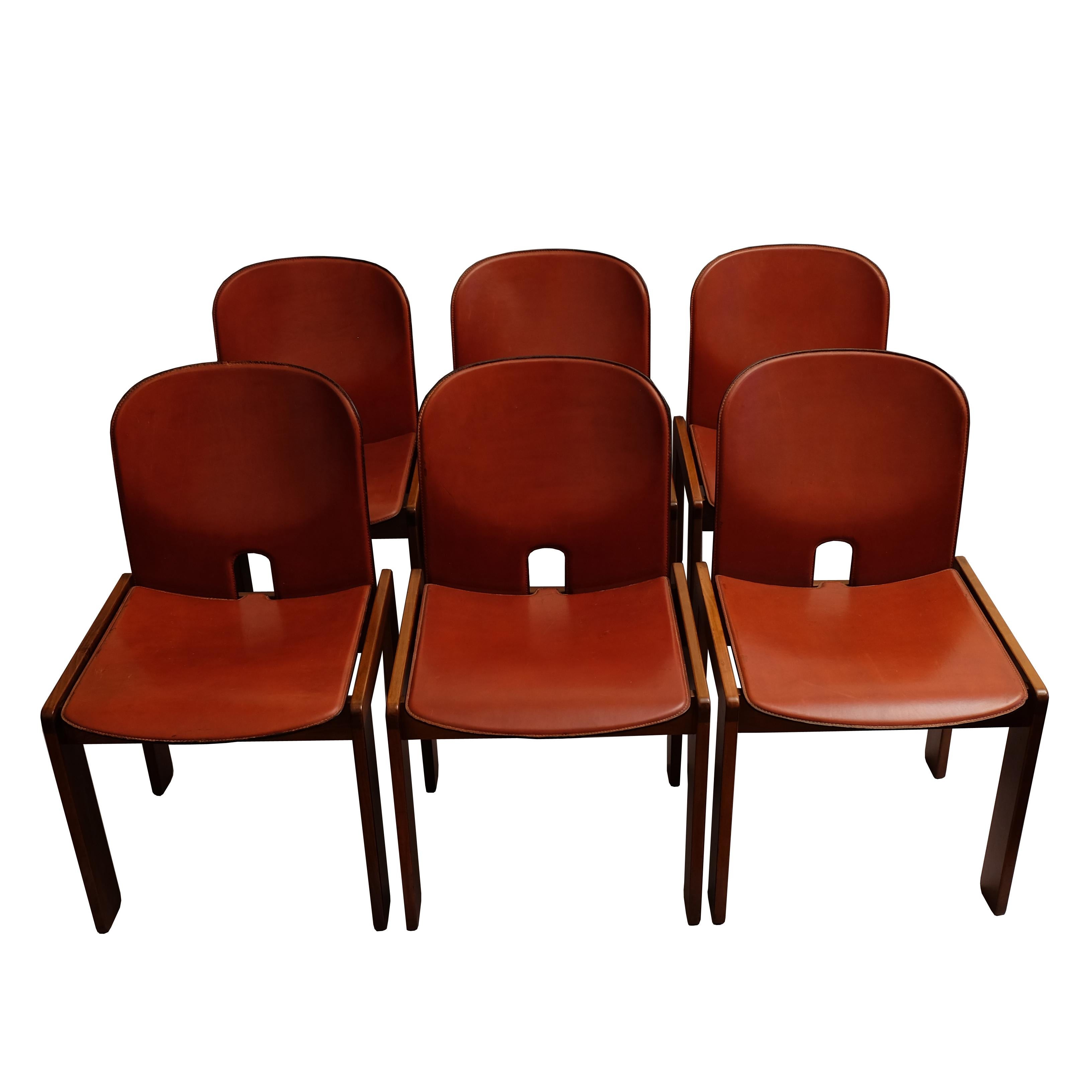 A set of six walnut and red leather chairs. The bent plywood arched back and seat upholstered with red leather and fixed on four joined walnut rectangular feet.
Manufactured by Cassina.
With manufacturer's labels underneath.

Literature:
Domus