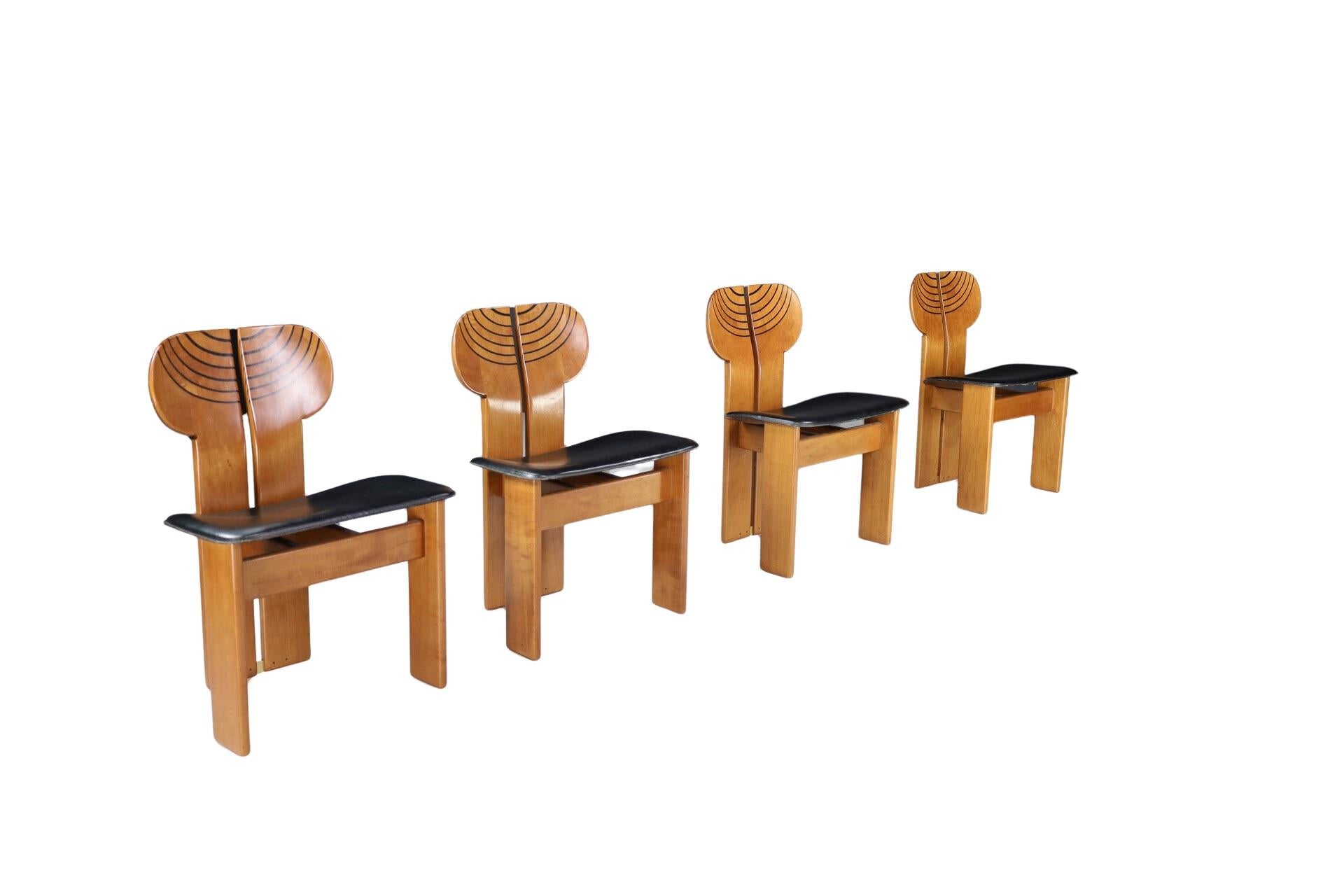 Set of four Africa chairs with a structure in walnut wood and burl, seats upholstered with beautiful high-quality leather and brass details. 

Originally hand finished and assembled one-by-one, 