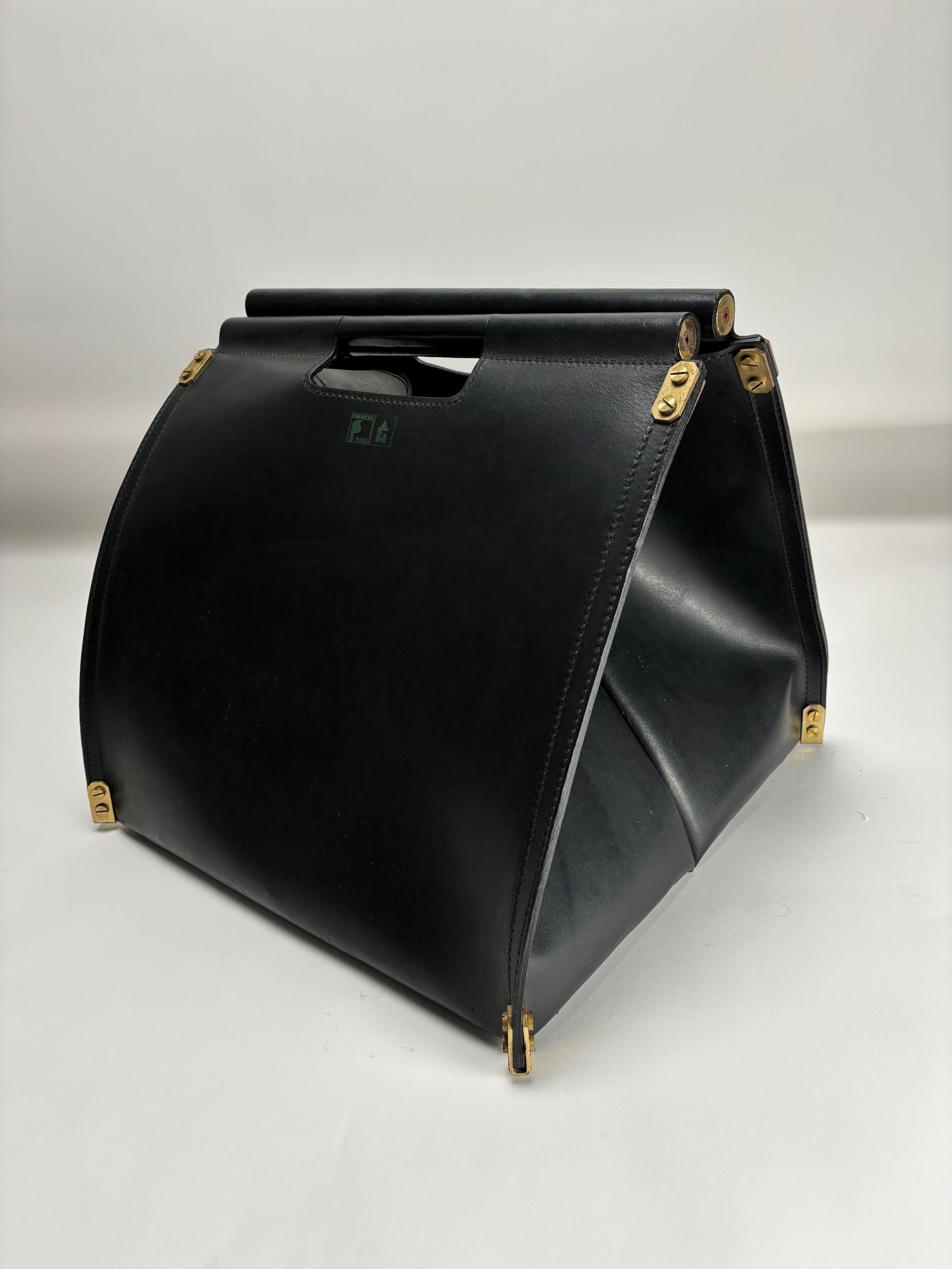 La borsa in pelle di alta qualità e ottone placcato oro è un elegante porta legna (o sacco per la legna da ardere) progettato dal duo di designer italiani Afra & Tobia Scarpa per Dimensionefuoco, un'azienda specializzata in accessori per caminetti