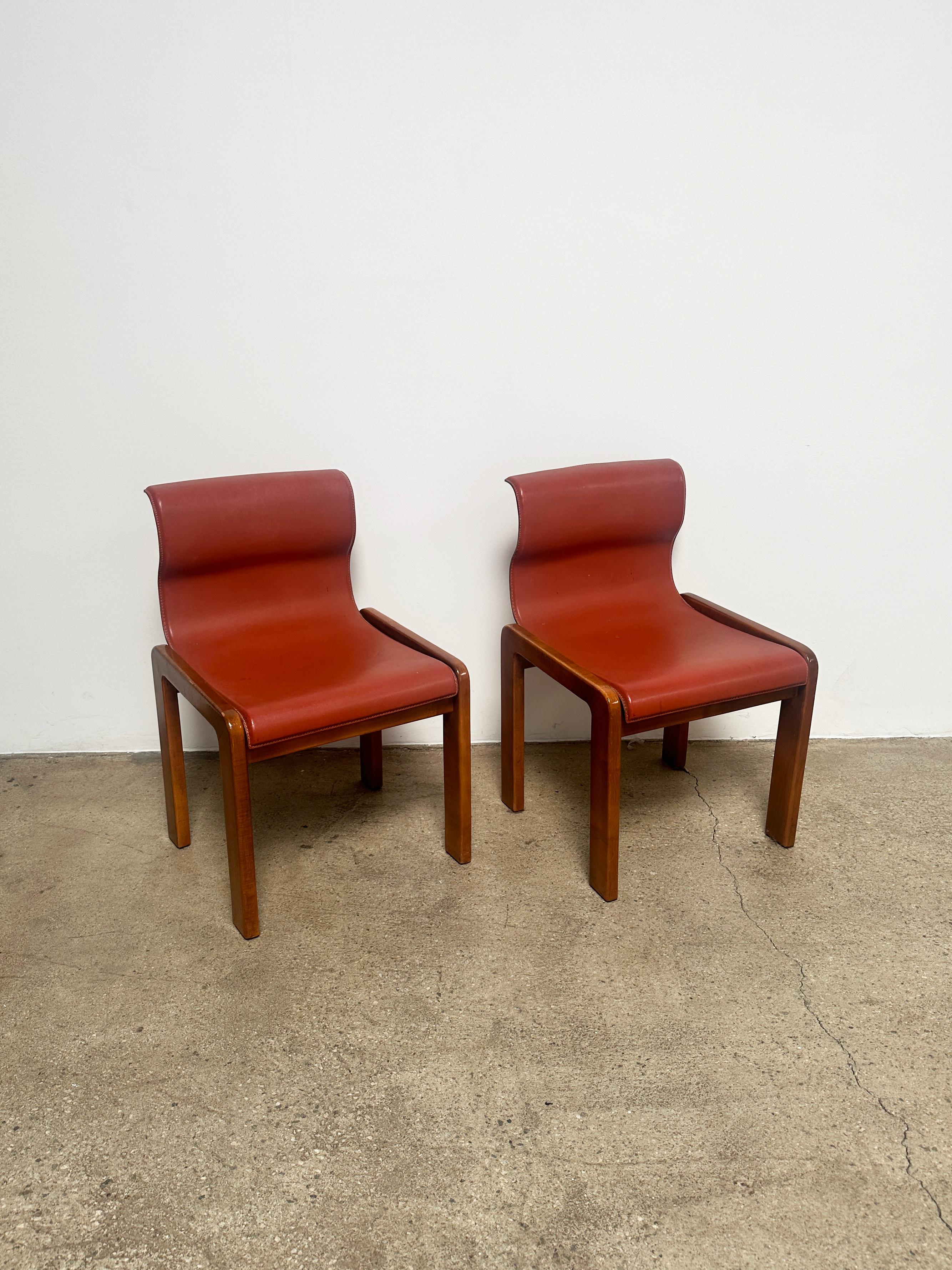 Set of four dining chairs designed by Afra & Tobia Scarpa in the late 60s. The legs are made of ash, and the seat and back made of plywood. It is upholstered with brick-colored leather, and presented in an ergonomic shape found in the late 80's