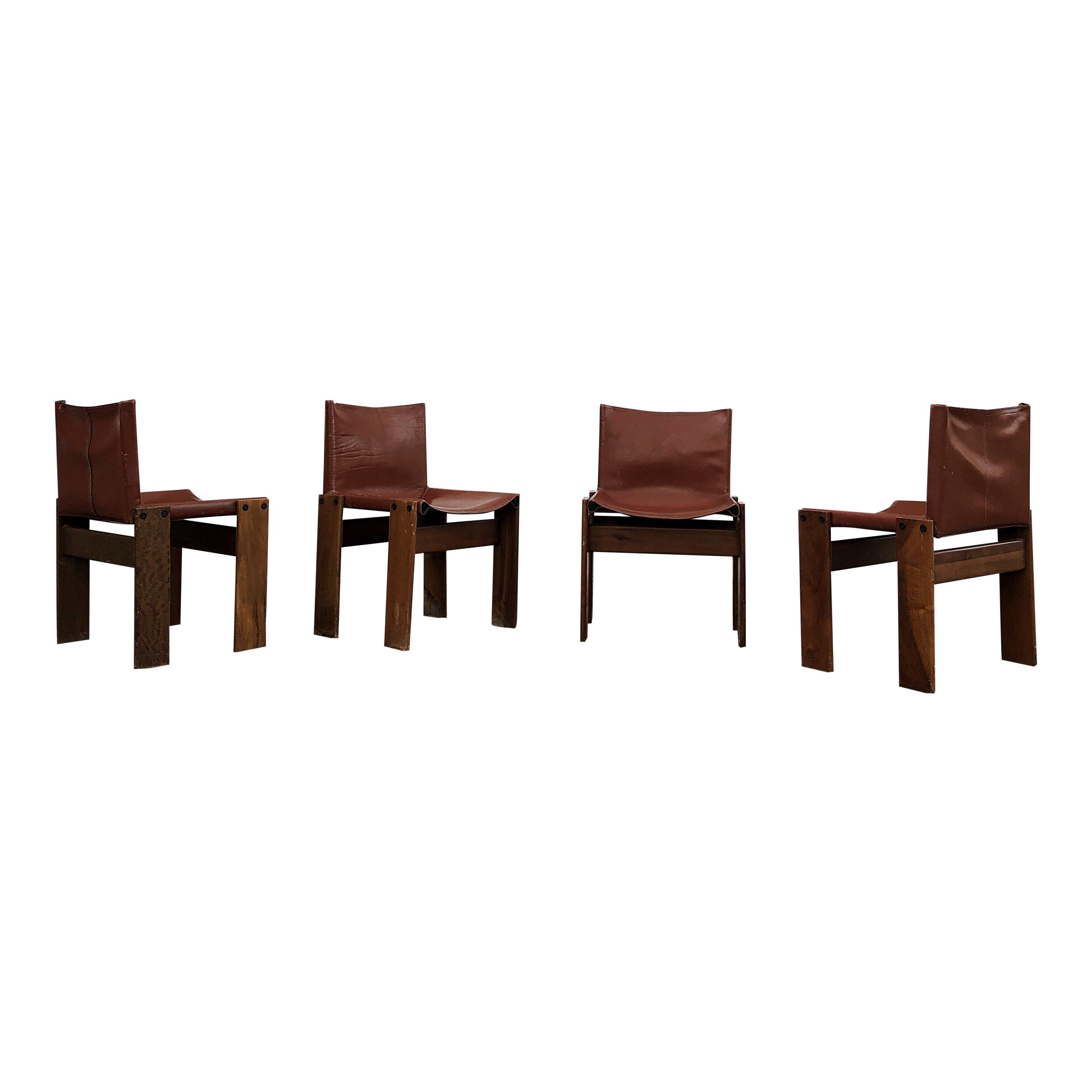 Afra & Tobia Scarpa, 4 monk dining chairs, walnut and bricky leather, Italy, 1973.
 Interesting is the 'flat' shape of this chair where the designer has chosen to place the legs cross-angled. 
This decision gives the chair the appearance of being