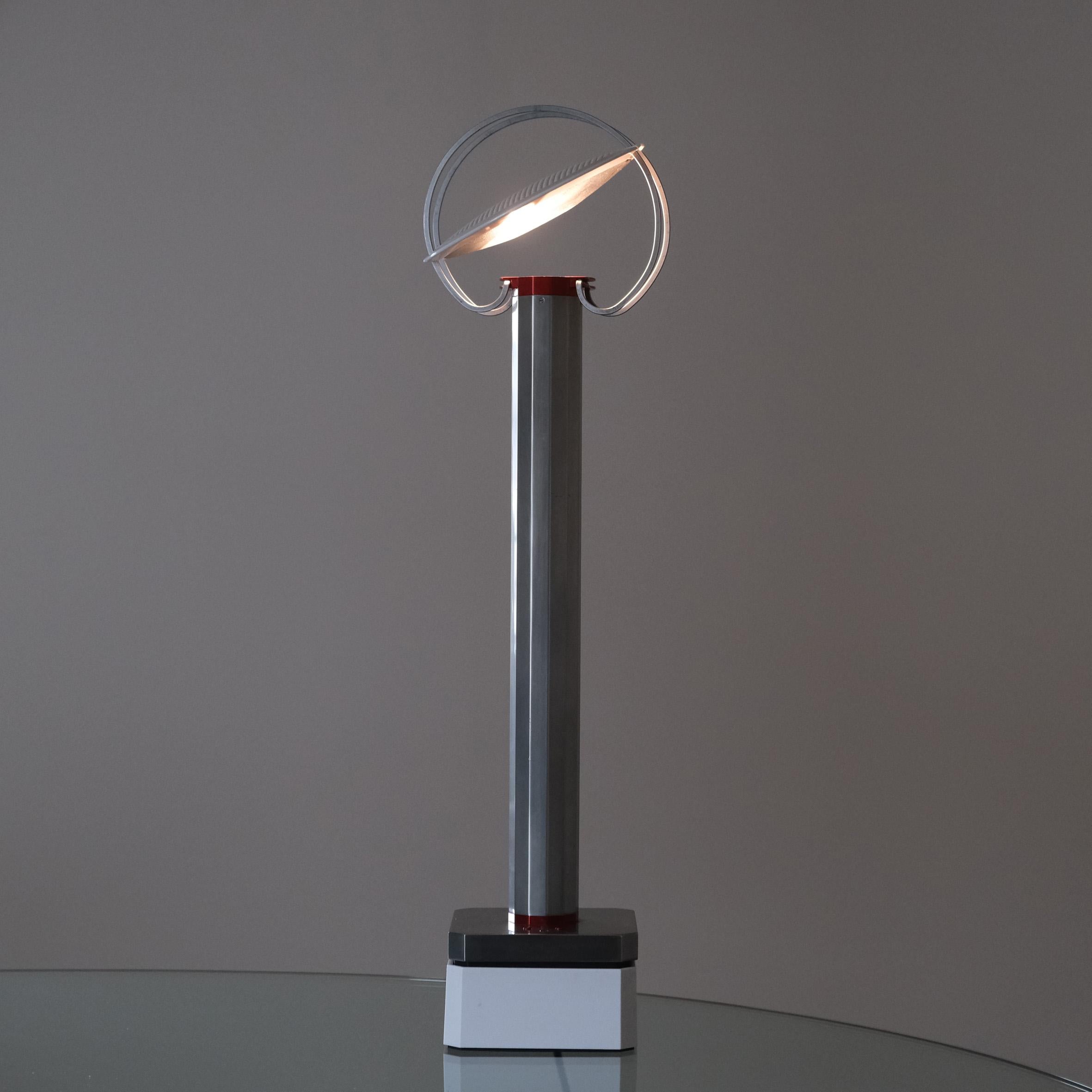 Afra & Tobia Scarpa (1935-2011 & 1935-)

« Perpetua »

An aluminum, steel and plastic portable table lamp, with a gray anodized aluminum stem issuing a vertical light reflected by a round mobile shade positioned on two circular steel tracks.
On a