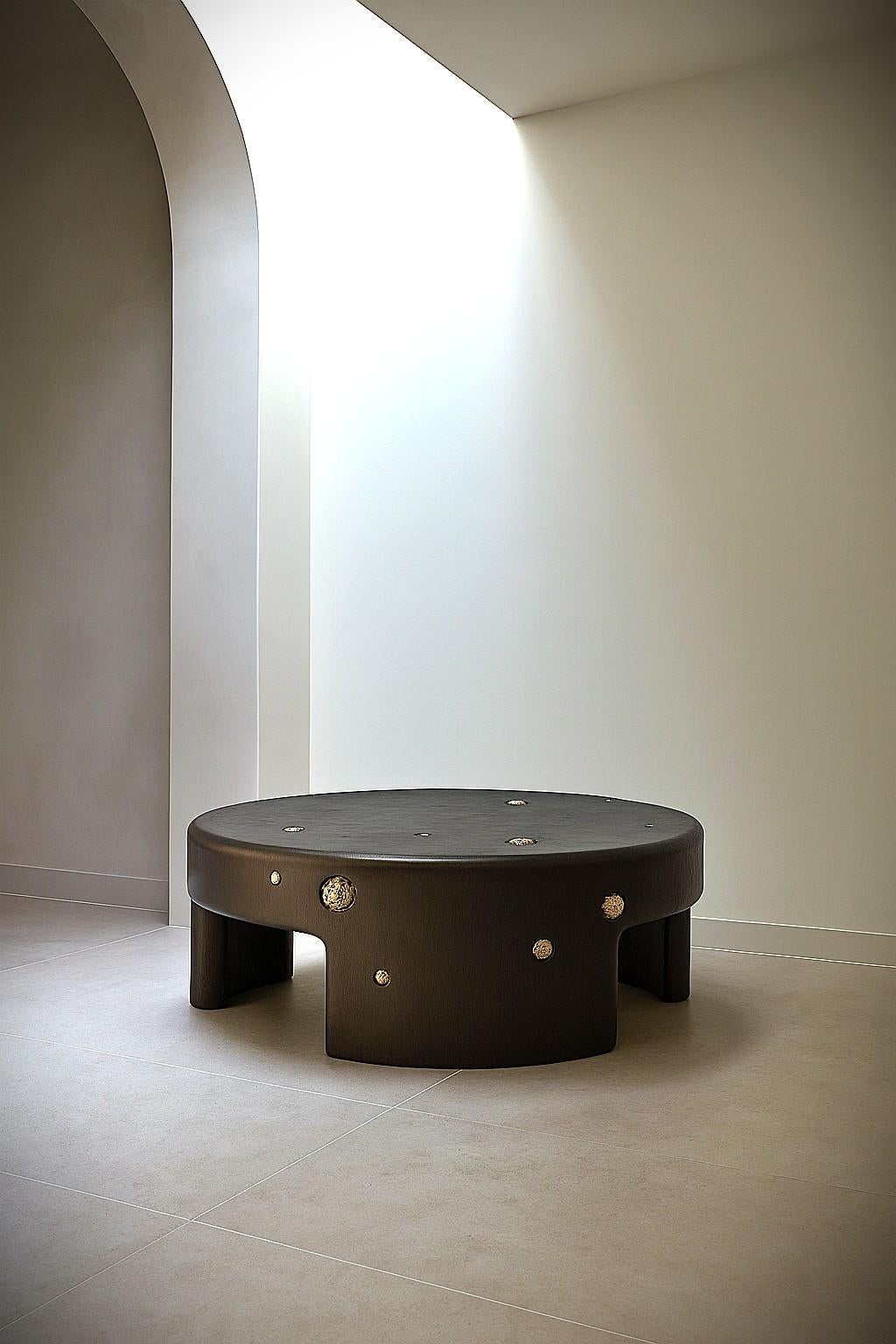 Dieser handgefertigte Couchtisch aus der Africa Collection'S bringt die skulpturale Sprache von Sidani Design durch eine kühne, monolithische Silhouette zum Ausdruck, die mit mineralischer Taktilität angereichert ist. Das Stück ist aus Massivholz