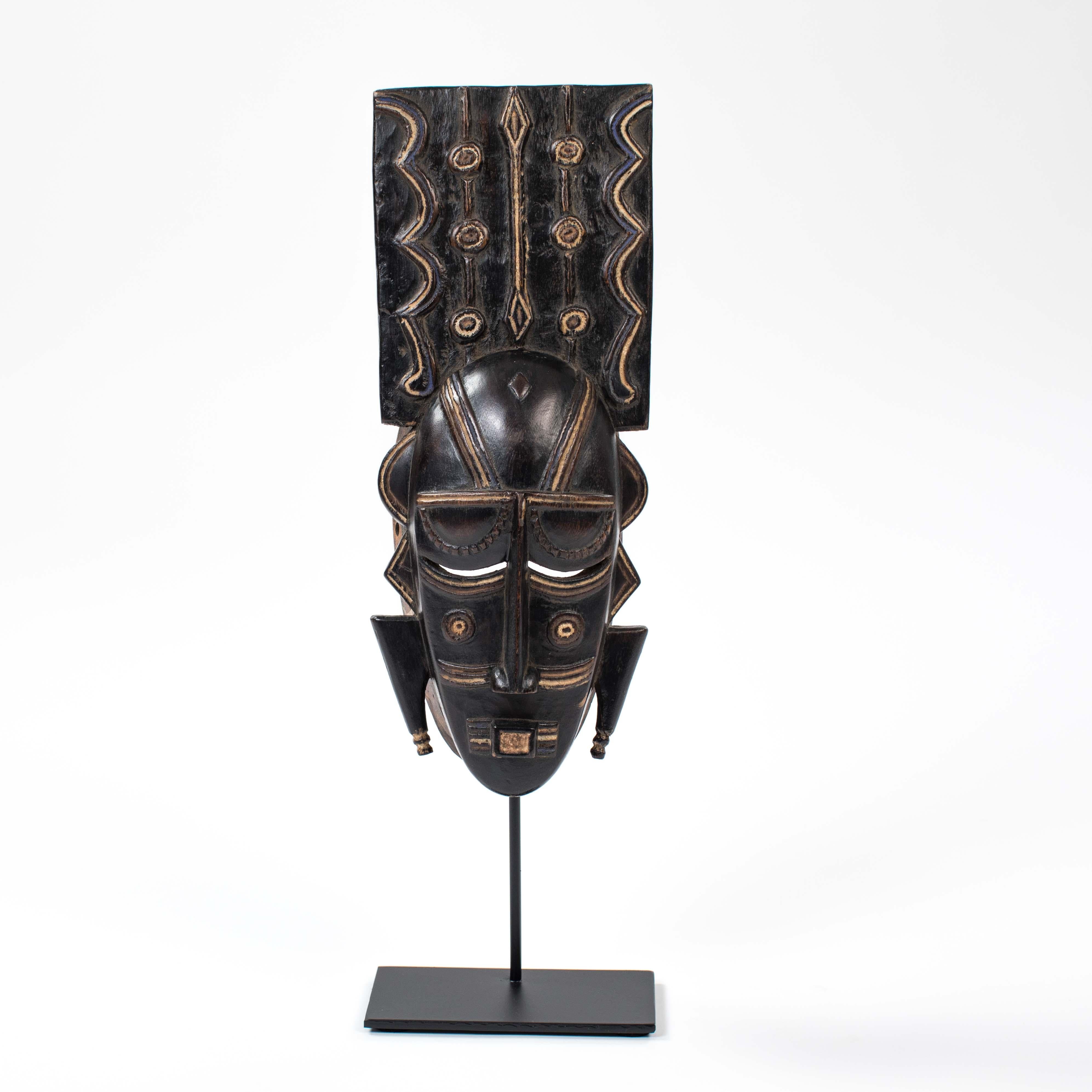 Ligbi mask, with a protruding plate on the head engraved with decorative motifs.
Highlights of blue pigments and kaolin enhance this small mask, satin black patina.
The appearance is austere, geometric and the brightly colored carvings lighten the