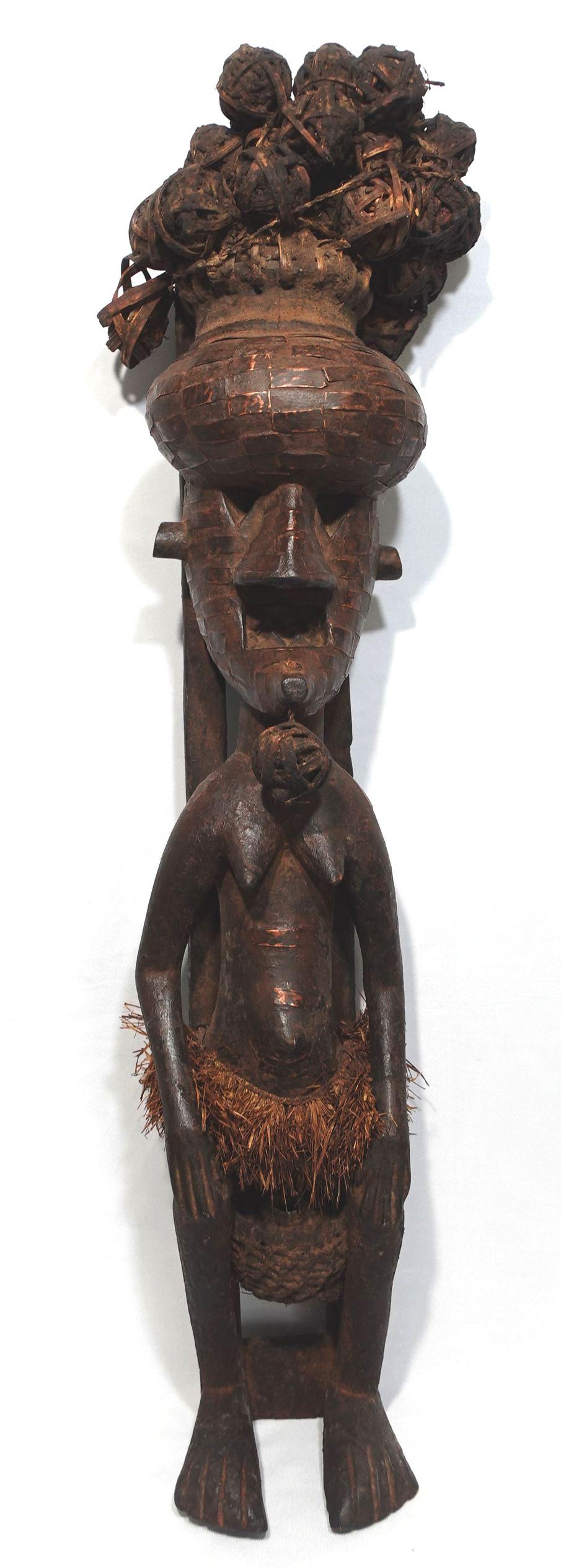 Statue précieuse d'art africain avec des boules de four en guise de cheveux, une texture en tressage de panier sur le visage et un pagne. Les panneaux en laiton sont appliqués sur l'ensemble de la tête et du visage et sur une partie du corps. La