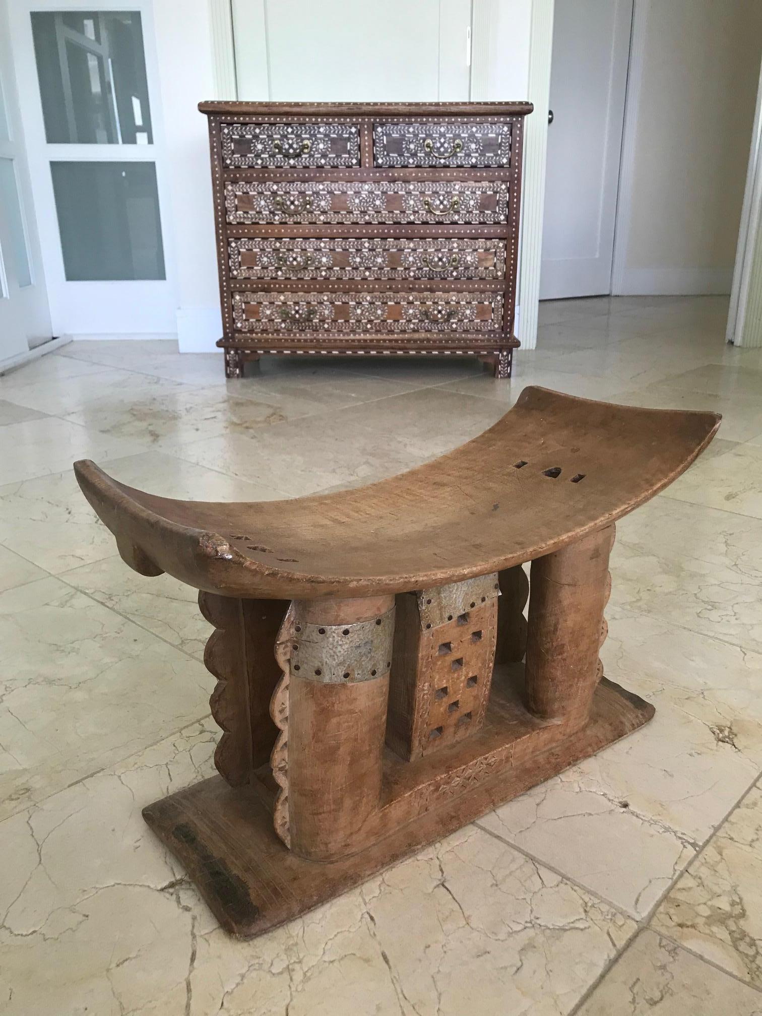 Genuine traditional African Ashanti stool signifying power and status, and symbolic of leadership. Carved from a single block of wood featuring curved seat and intricate support base. The stool features a series of incised tribal carvings, hand