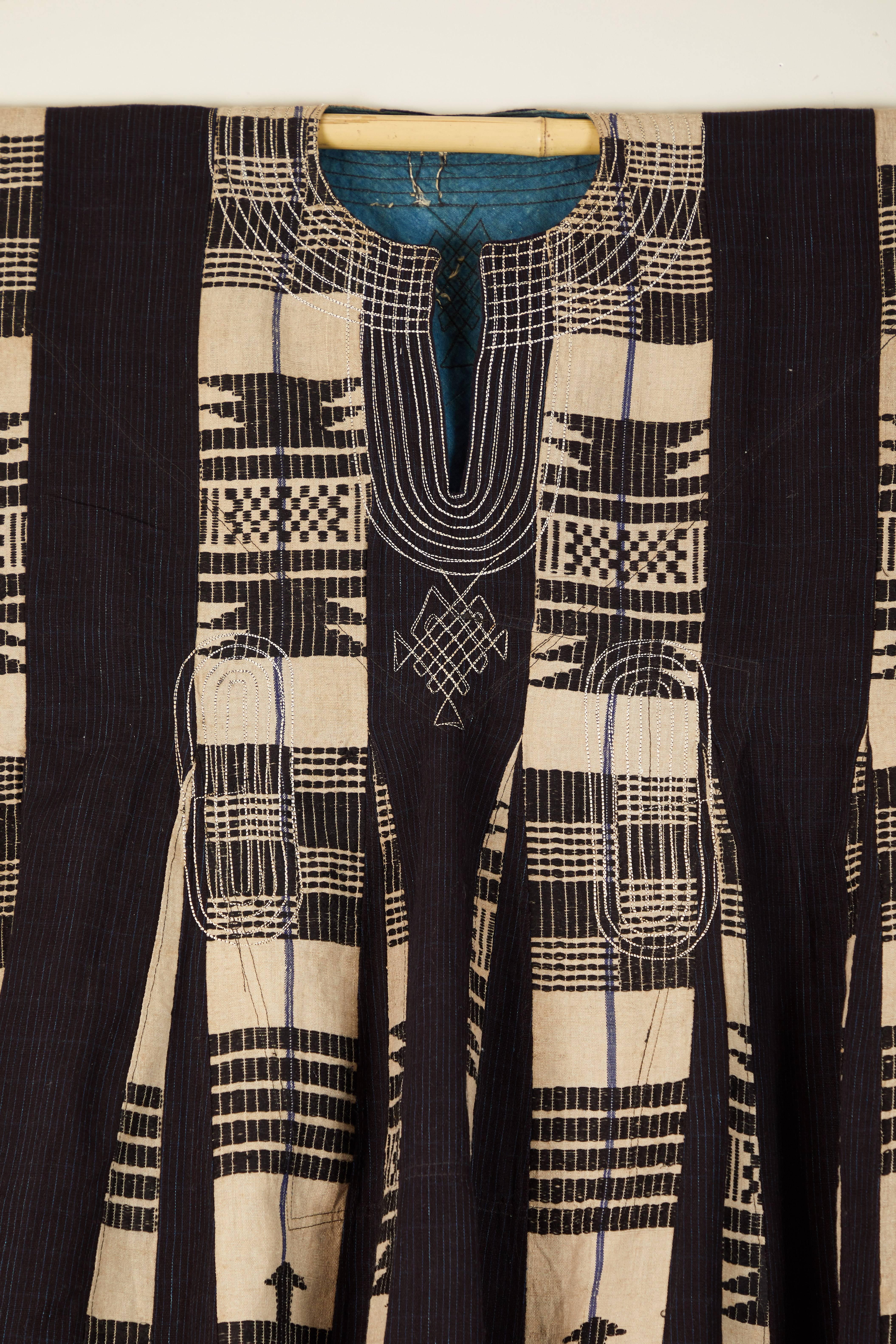 Traditional man's cotton tunic made from handwoven, supplementary weft narrow strips sewn together.