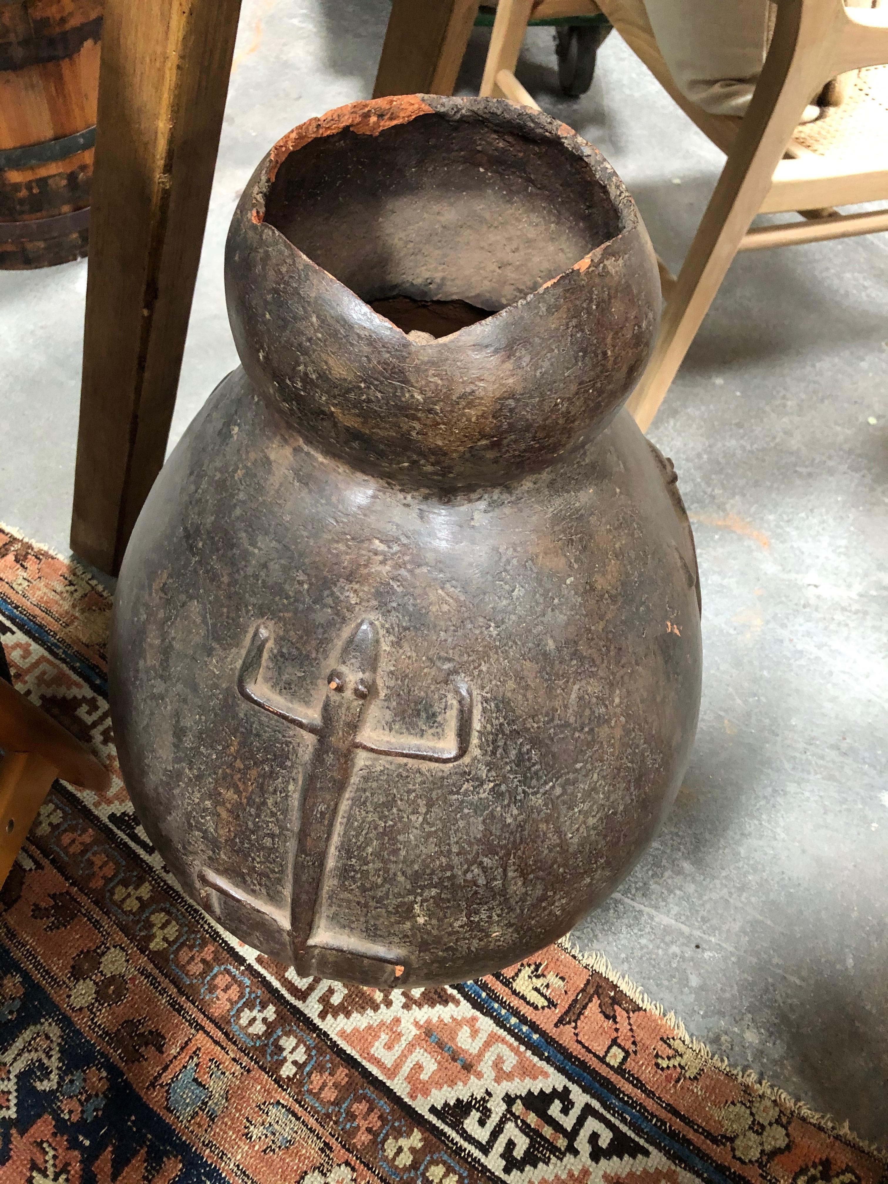 Ce pot africain Bamana présente un motif de lézard en relief, suggérant sa fonction liée à l'eau, ce qui indique qu'il s'agit d'un pot domestique utilisé pour stocker et servir de l'eau. Bien que les femmes créent les pots, les hommes les offrent en