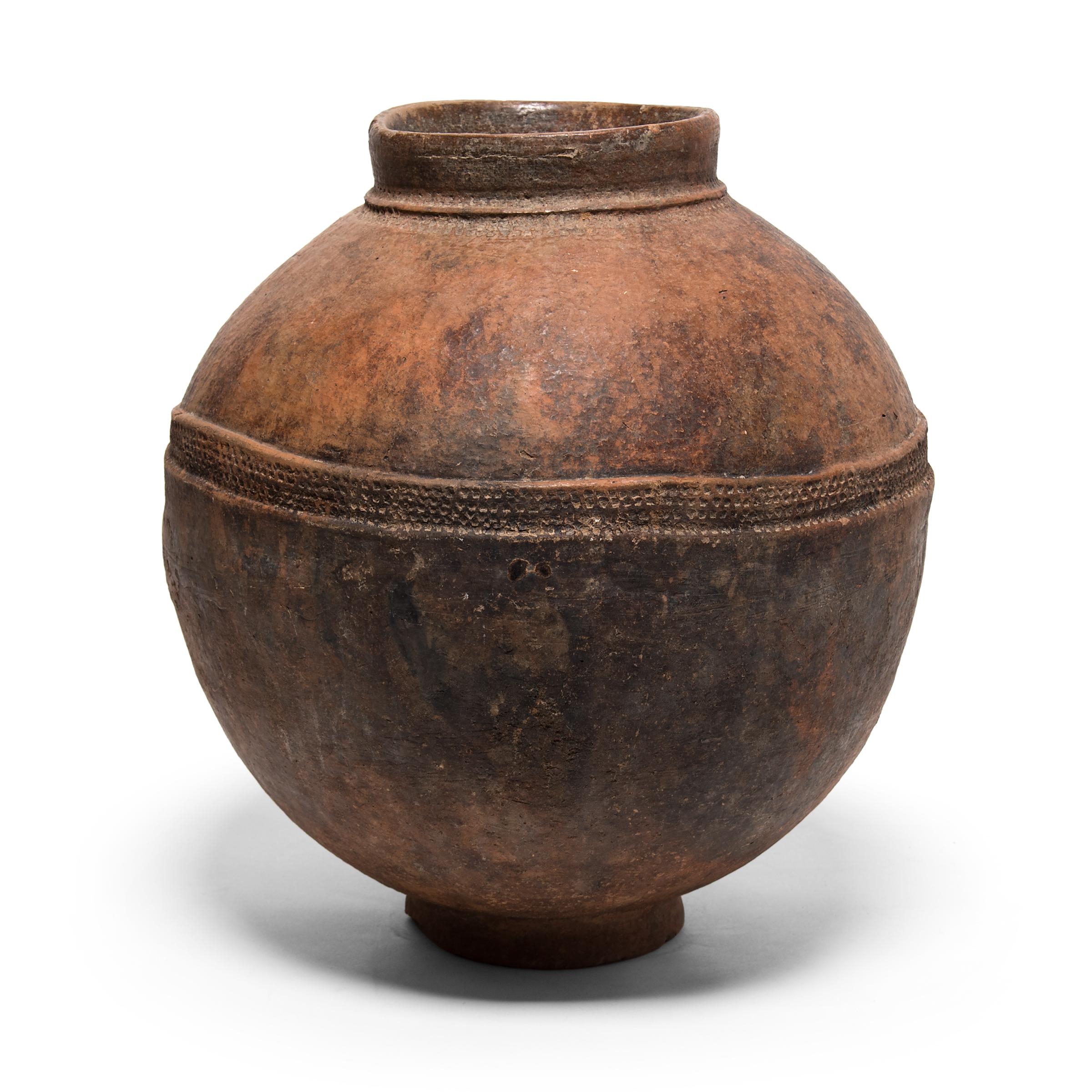 Formed by pounding flattened clay around a convex mold, this well-proportioned vessel is a water storage vessel known as a jidaga, created by women of the Bambara people of Mali. Although the vessel's small mouth is uncommon for a water jar, the