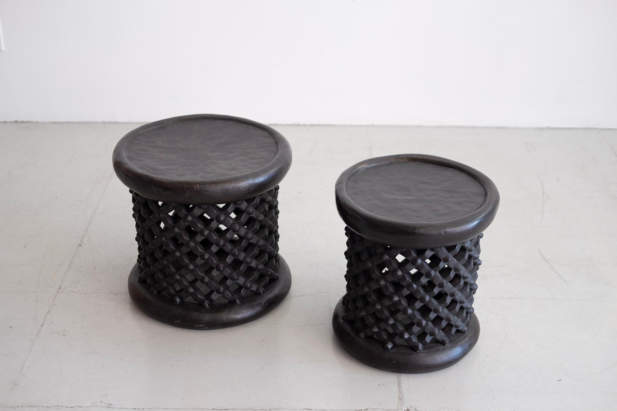 Two African Bamileke spider stools or tables in ebonized wood with intricate carved lattice detailing. Sold and priced individually. 

Measures: Large - 17