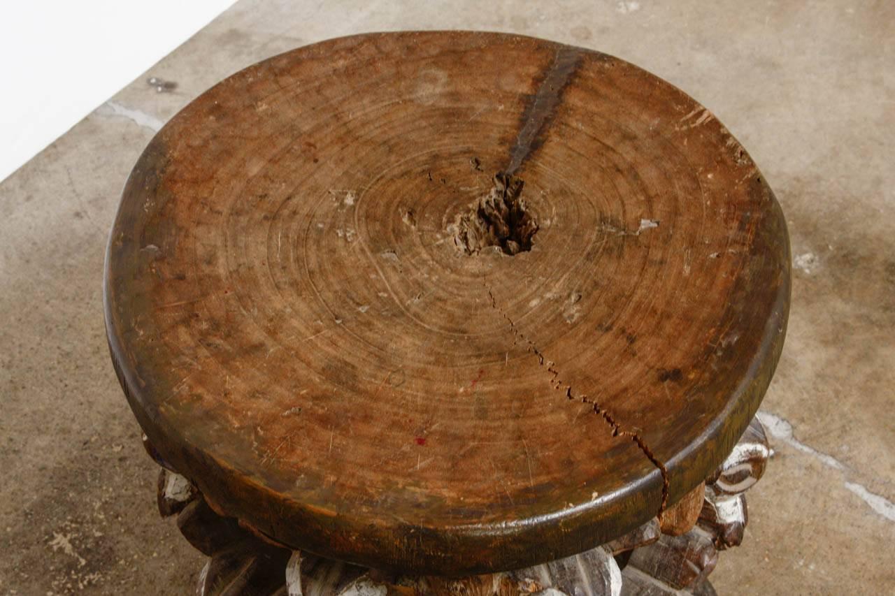 Interesting African hand-carved Bamileke stool or drinks table from Cameroon. Featuring an animal head motif body. Carved from a stump in a tribal design with paint remnants. Beautiful distressed patina.