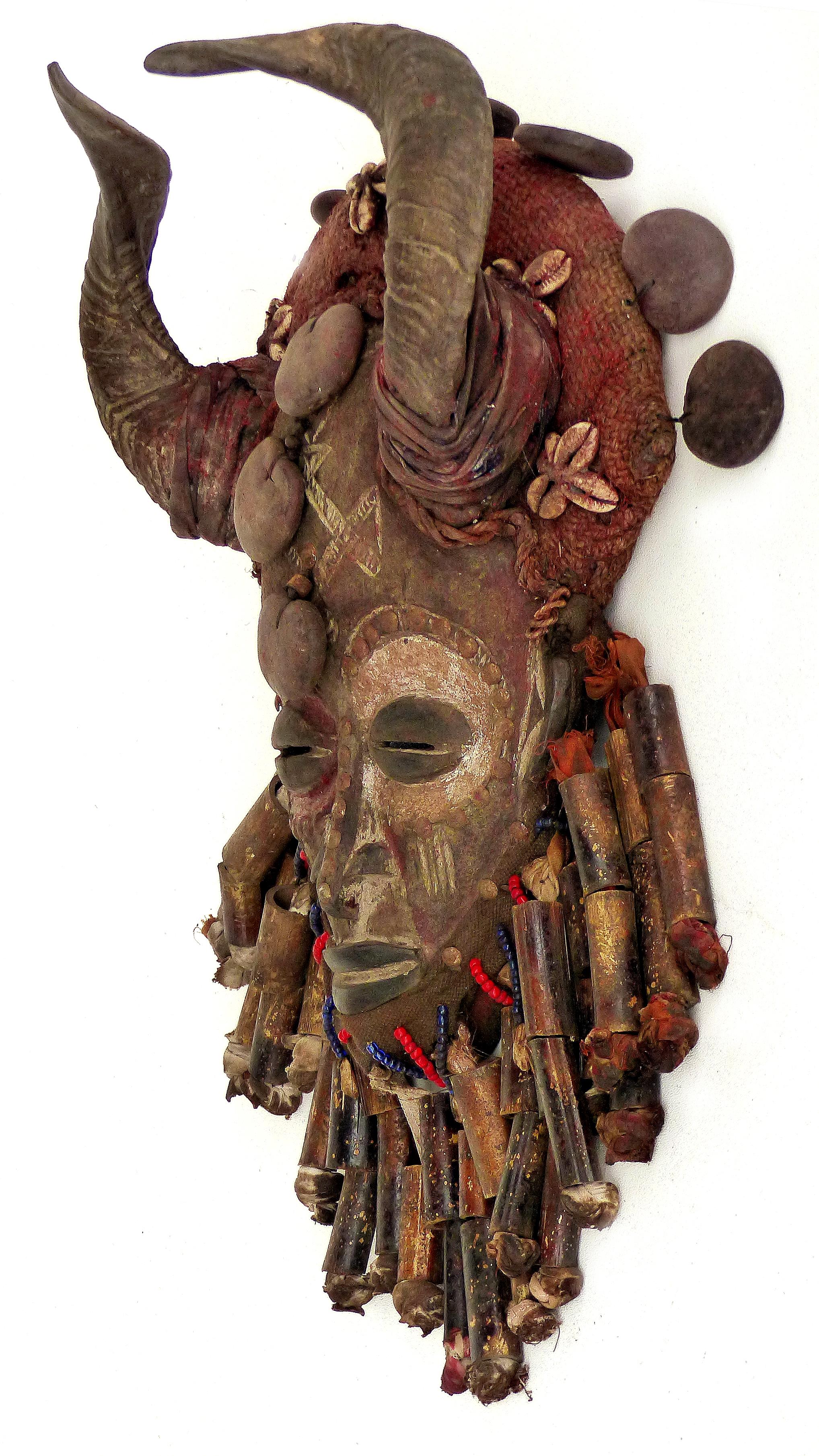 African Bamileke Tribal Mask from Cameroon with Horns

Offered for sale is a decorative carved mask from the Bamileke people of Cameroon, Africa, This interesting and unusual horned mask is embellished with beads, a bamboo beard, cowry shells and
