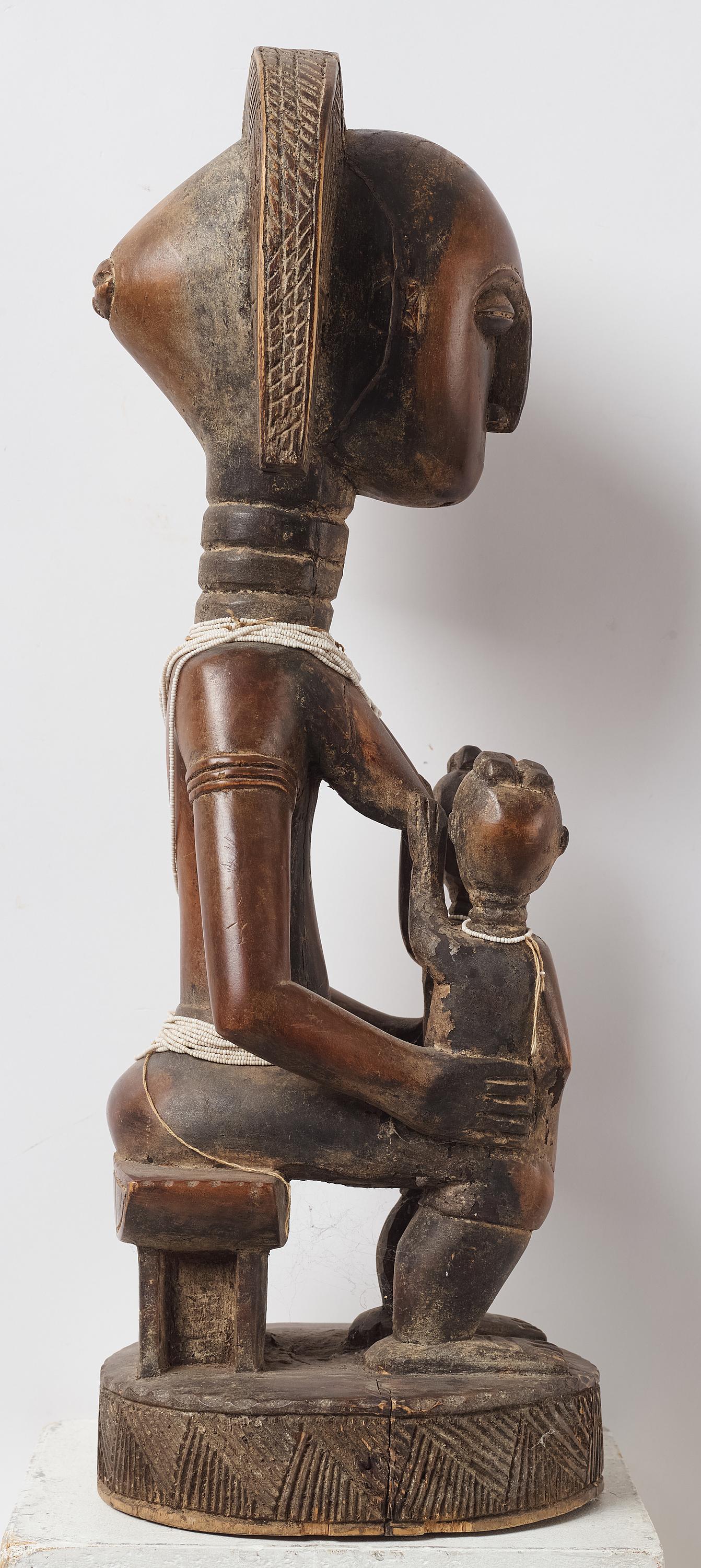 Afrikanische Baule-Statue Mutter mit Kind, Elfenbeinküste Mitte  XXem
Provenienz: Schwedische Privatsammlung, aus den 1980er Jahren. Dann wird es innerhalb der Familie vererbt.
Schöne Baule-Mutterfigur, die auf einem traditionellen Schemel sitzt und