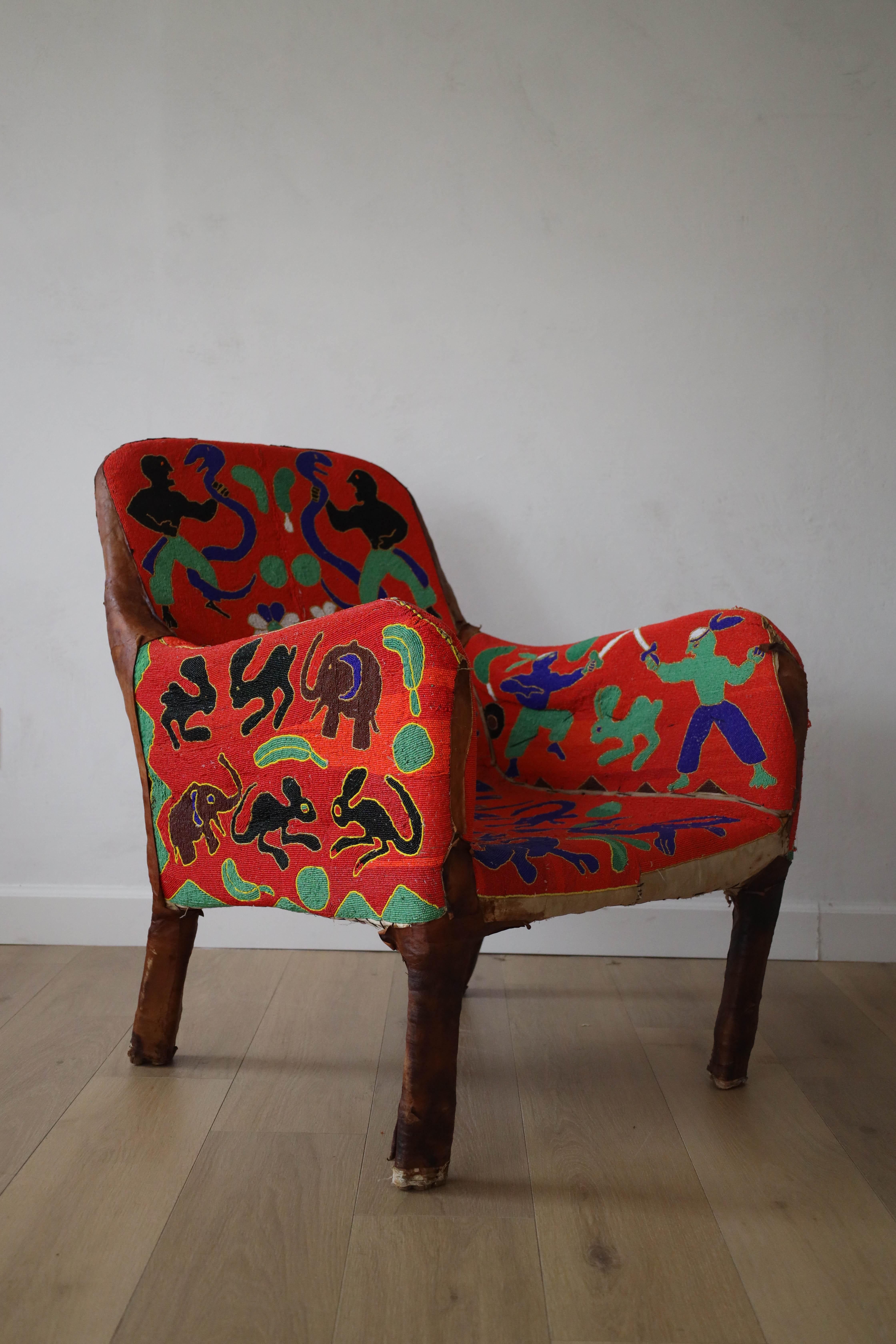 Régalez-vous avec cette œuvre d'art : La chaise Yoruba. Originaire du Nigeria, cette chaise est créée avec des milliers de perles cousues à la main, ce qui prend en moyenne trois mois. Cette chaise Yoruba particulière a une forme, un motif et une