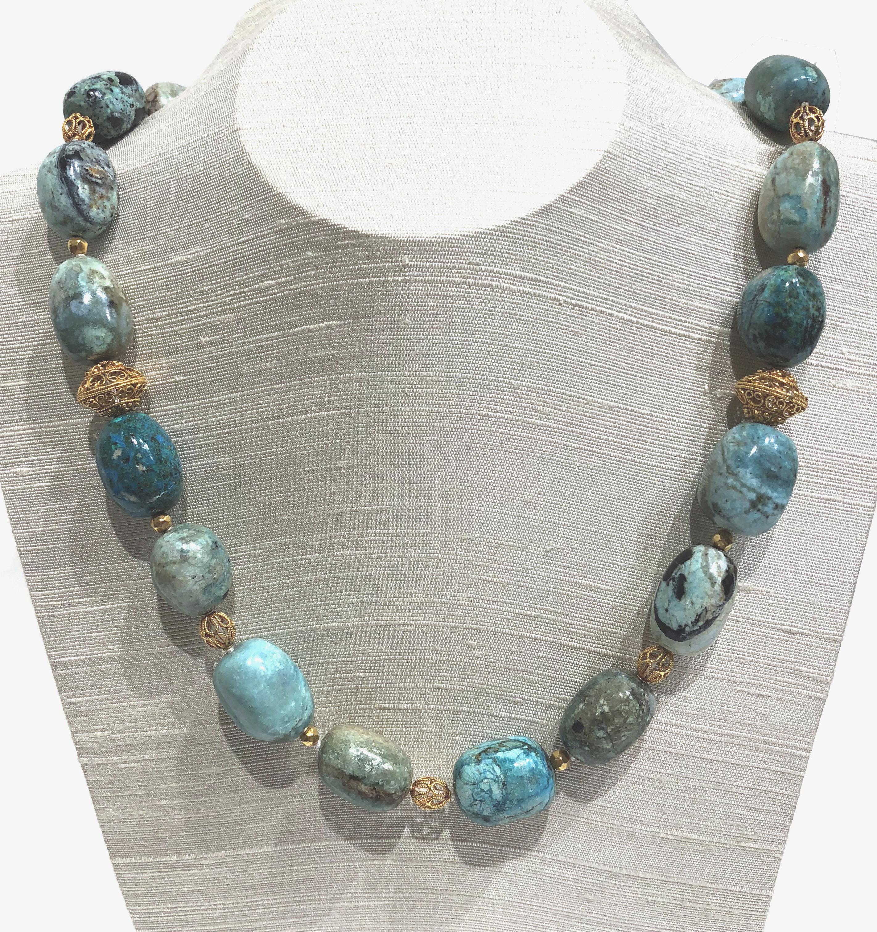 21 in (53.4cm) necklace with African blue opal beads and 18K gold beads & clasp.

The beautiful necklace with organic African Blue Opal beads is enhanced by ribbed 18K gold beads and gold clasp. 
