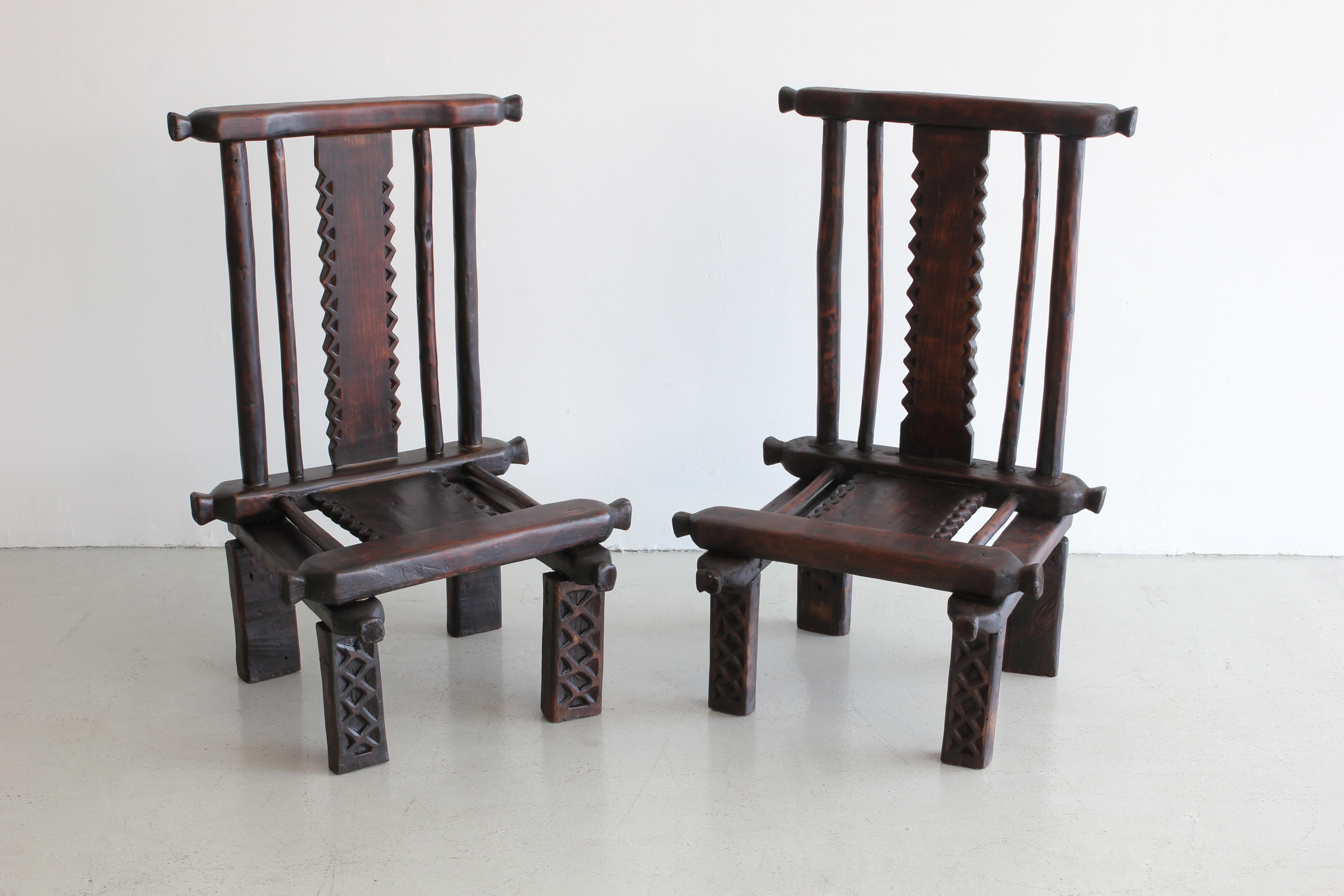 Pair of carved African chairs with ornate detail and fantastic shape and patina.