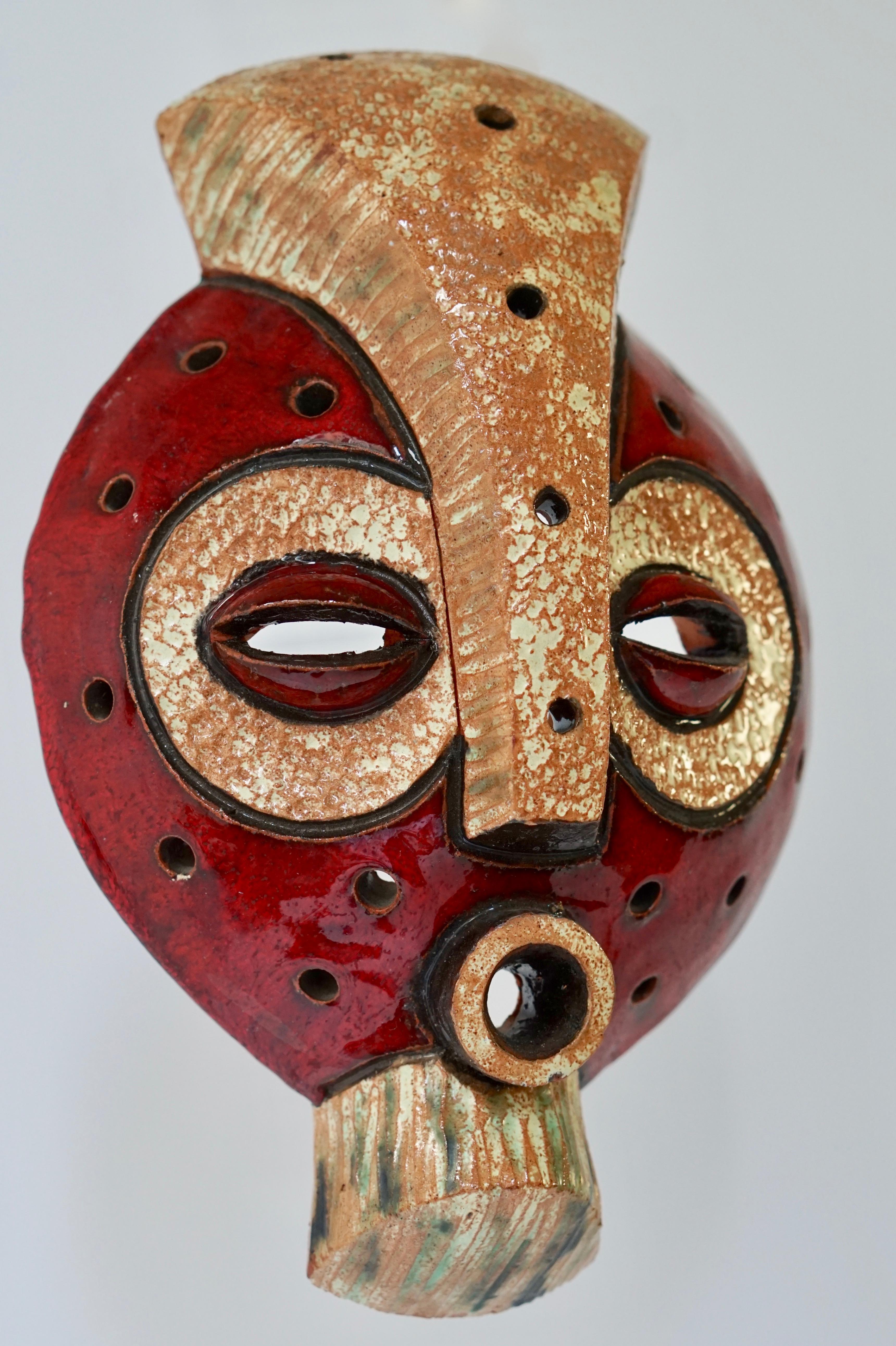 A relief of an African tribal mask, red glaze on brown fired clay.
Signed Napewaa.
Measures: Height 23 cm.
Width 12 cm.