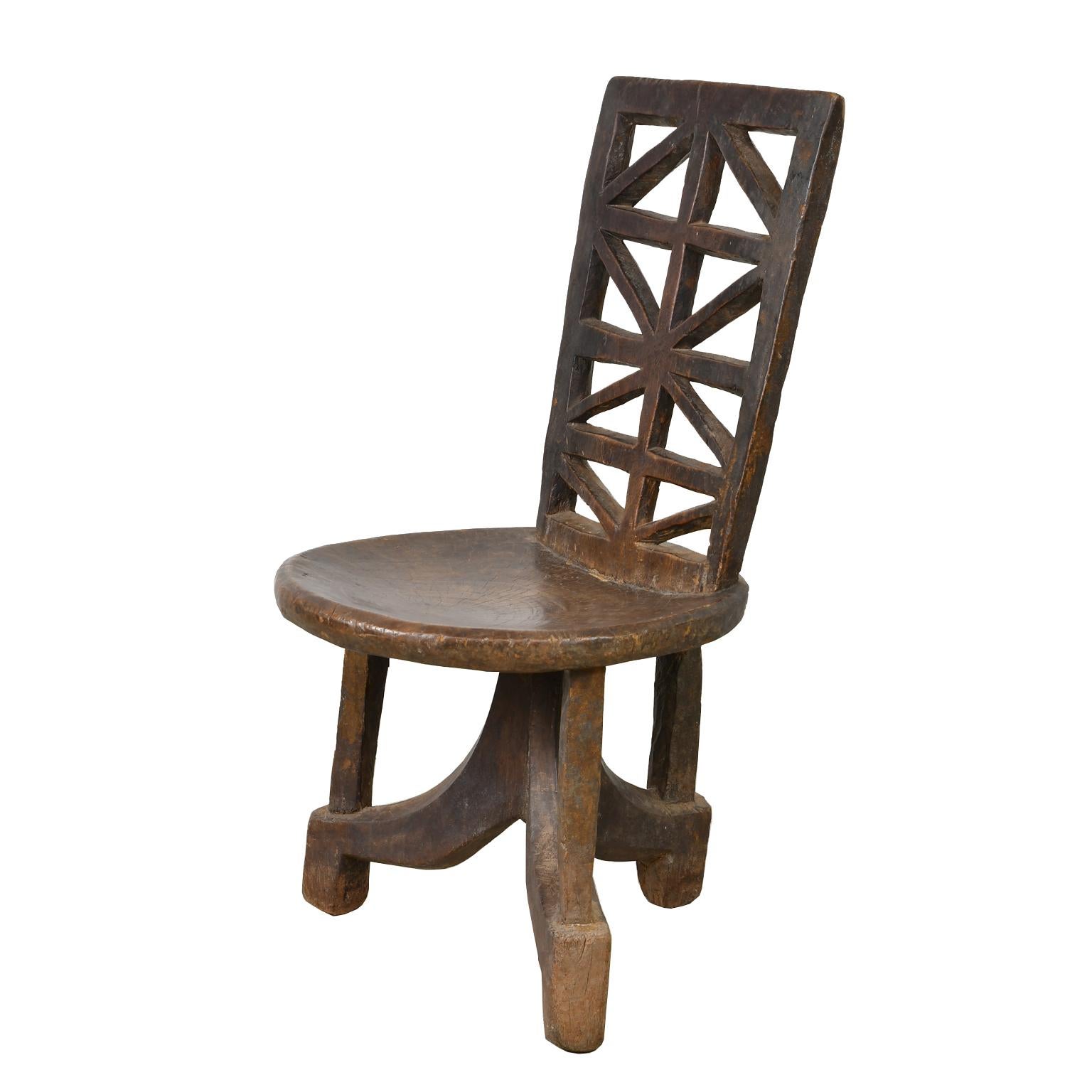 This beautiful tribal chair is carved from one piece of wood and was traditionally reserved for the chief of the village. It is distinctive with its three legs and its high back which is carved in a traditional geometric design. Ethiopia, Africa,
