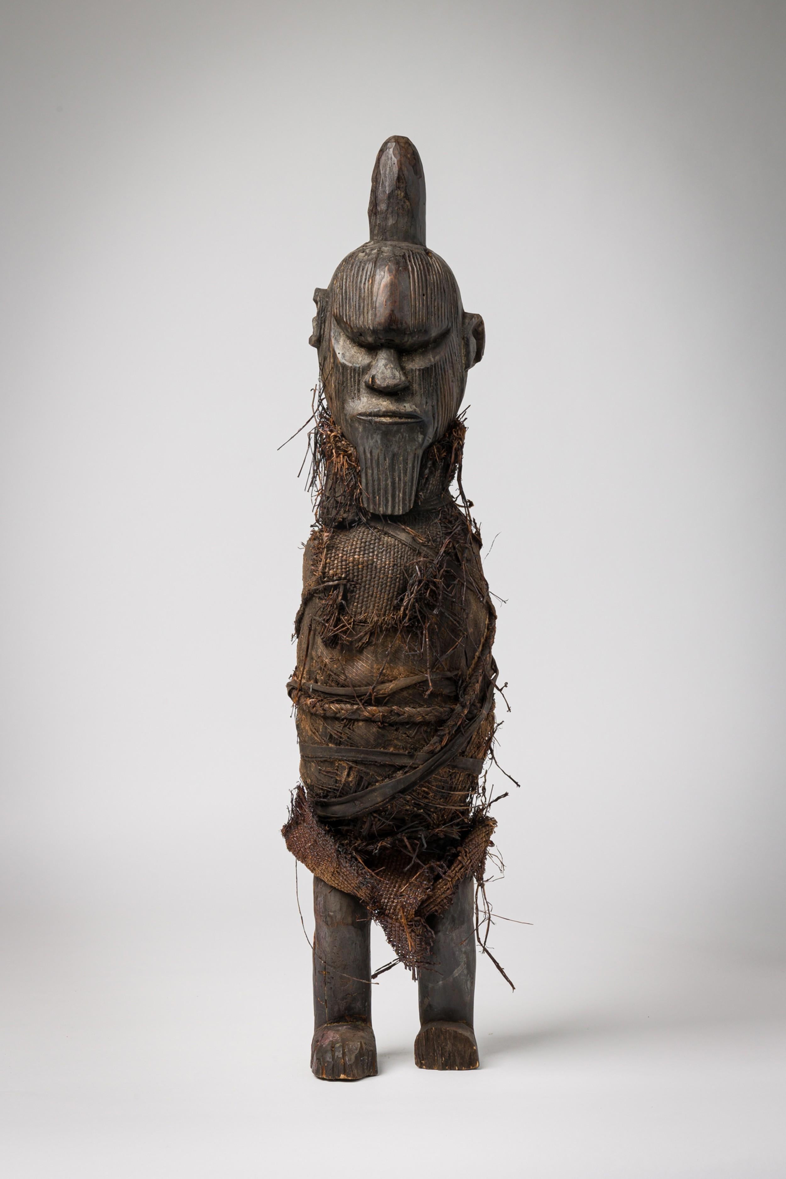 Figura masculina Teke africana del siglo XX, tallada a mano y envuelta en una arpillera de rafia

Bueno/Malo, con pátina que incluye roces y variaciones en el acabado, suciedad en la tela, líneas de pelo, pequeñas pérdidas y posibles reparaciones