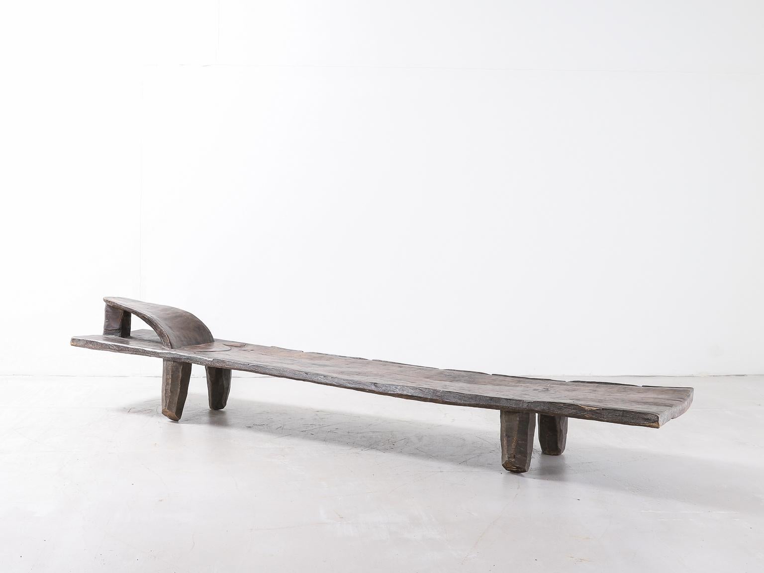 An early 20th Century African daybed in solid rich dark hardwood.