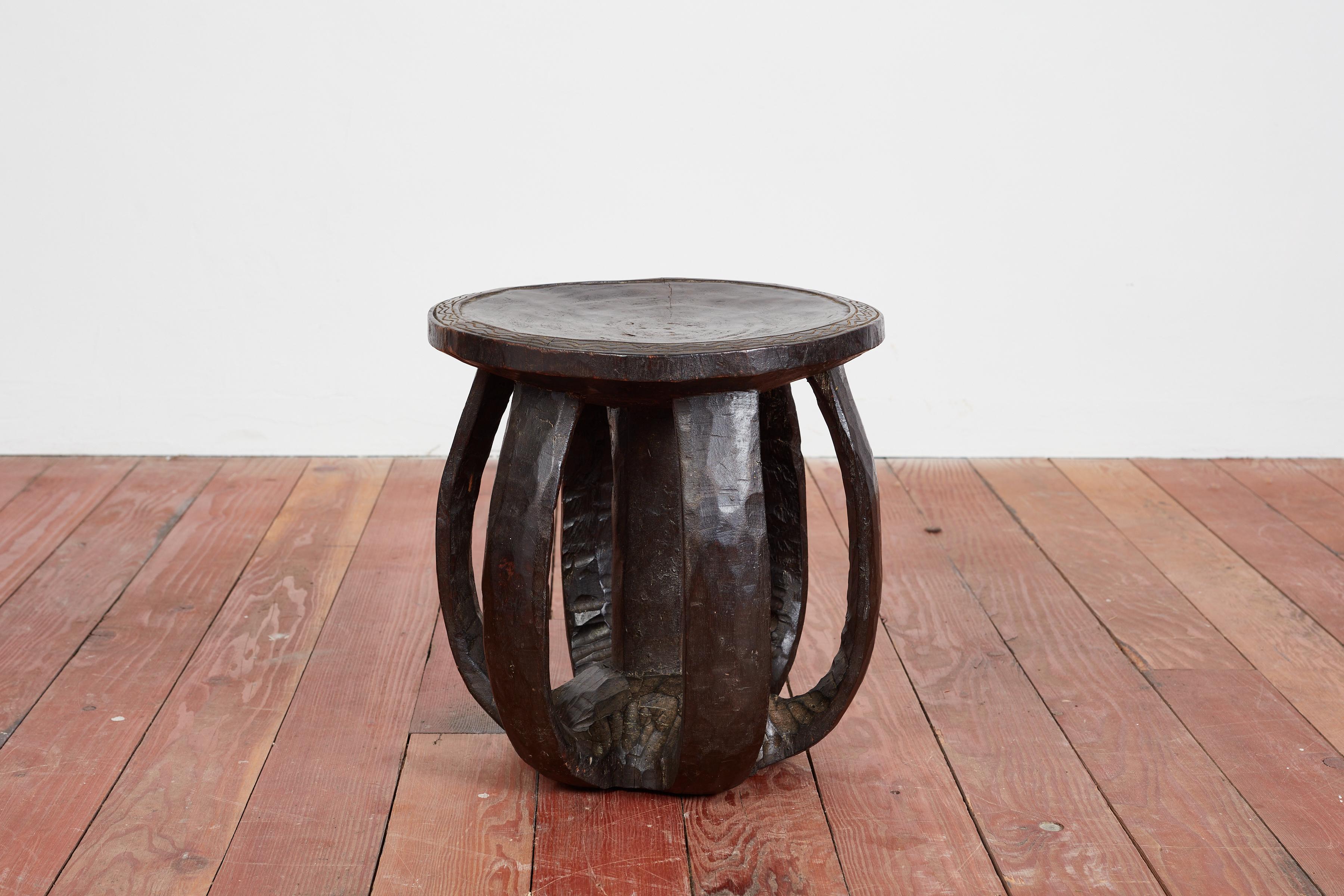 Wonderful African carved drum shaped side table with carved edges around table top. 

Interesting bowed legs, fantastic patina